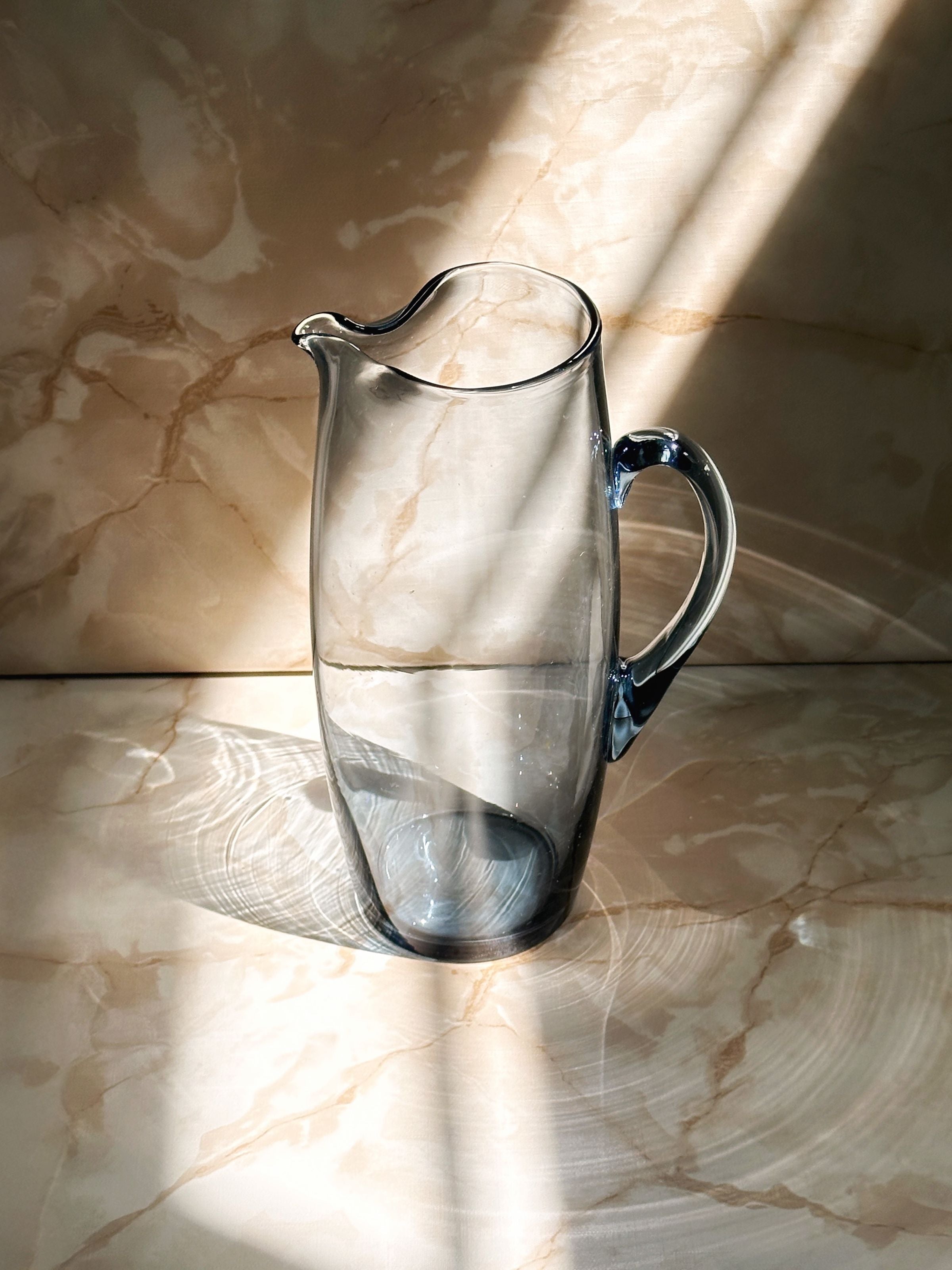 Clear glass Scandinavian carafe 1950s on marble surface