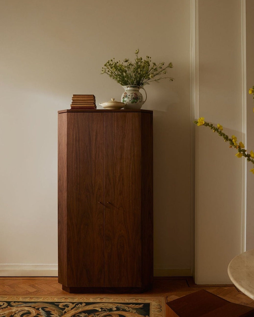 Winston walnut drinks cabinet styled with books and ceramic vase