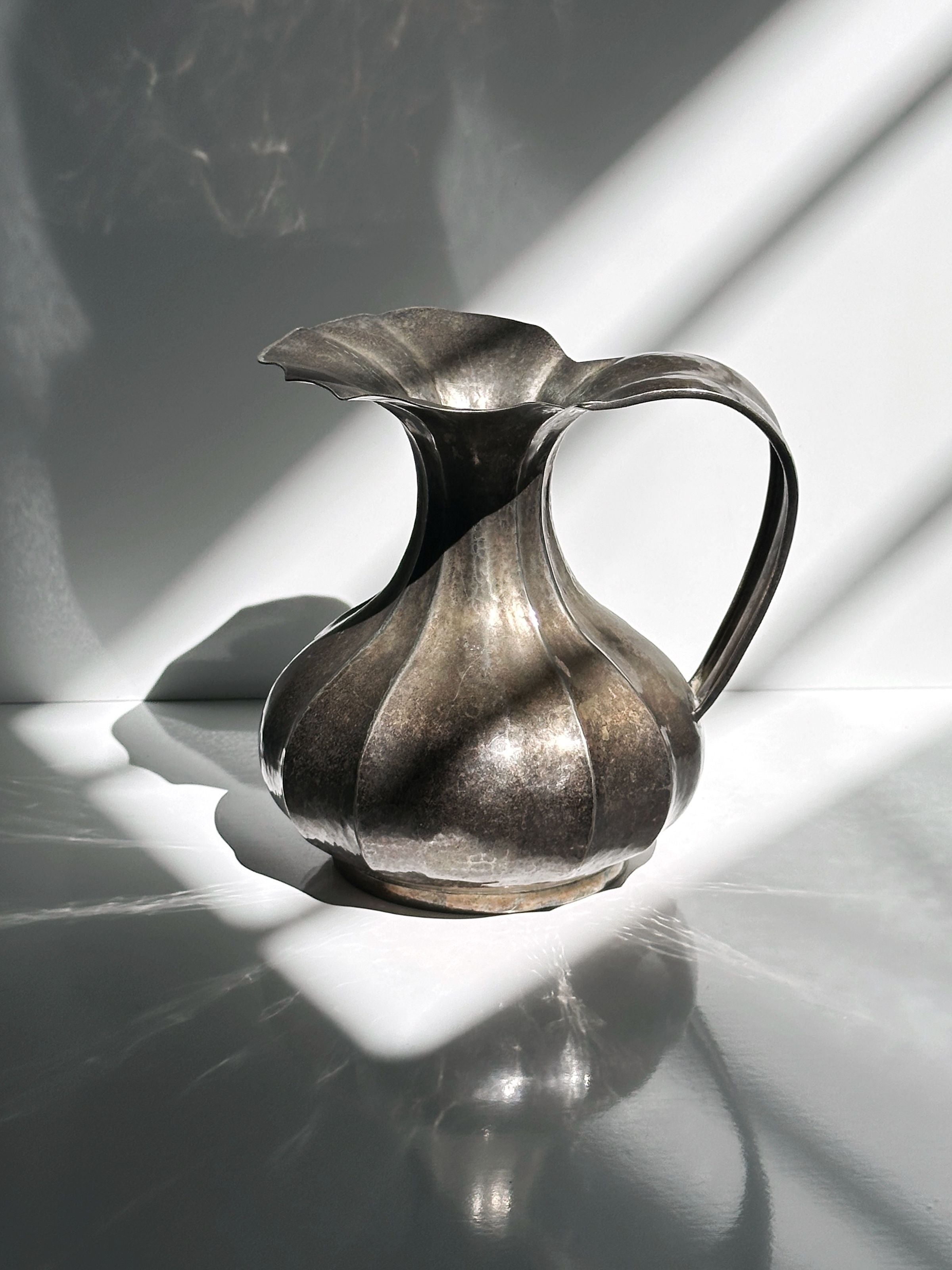 Silver-plated Art Nouveau vase with flowing ribbed design and handle