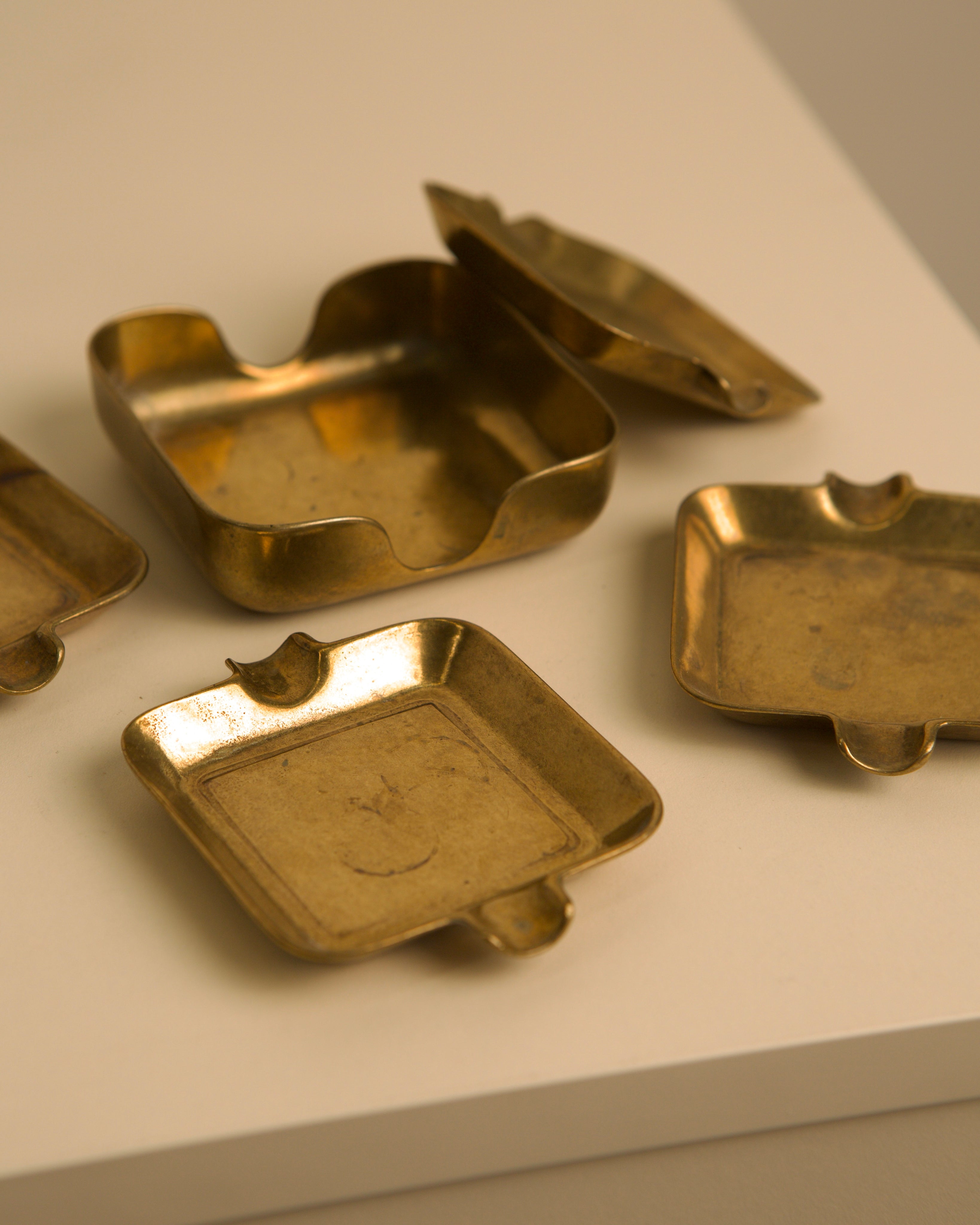 Golden brass Italian ashtrays showing detailed surface patina