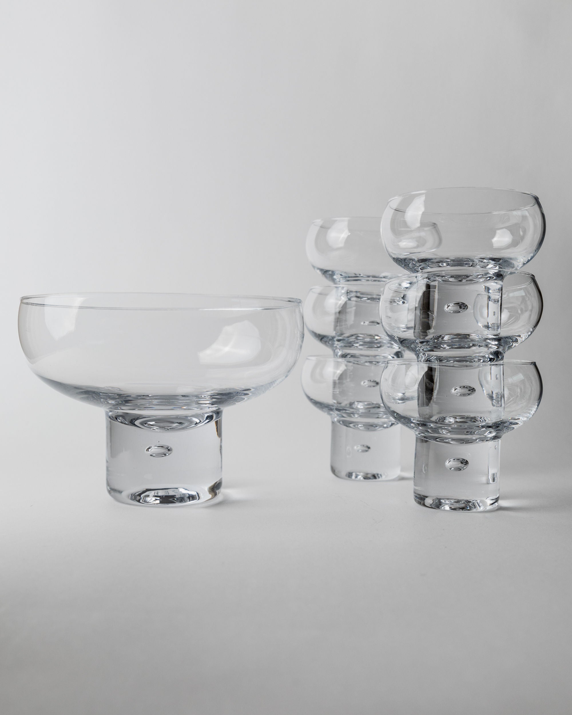 Set of 6 Glasses and 1 Bowl by Vicke Lindstrand, Italy 1960s — angled view on light gray background