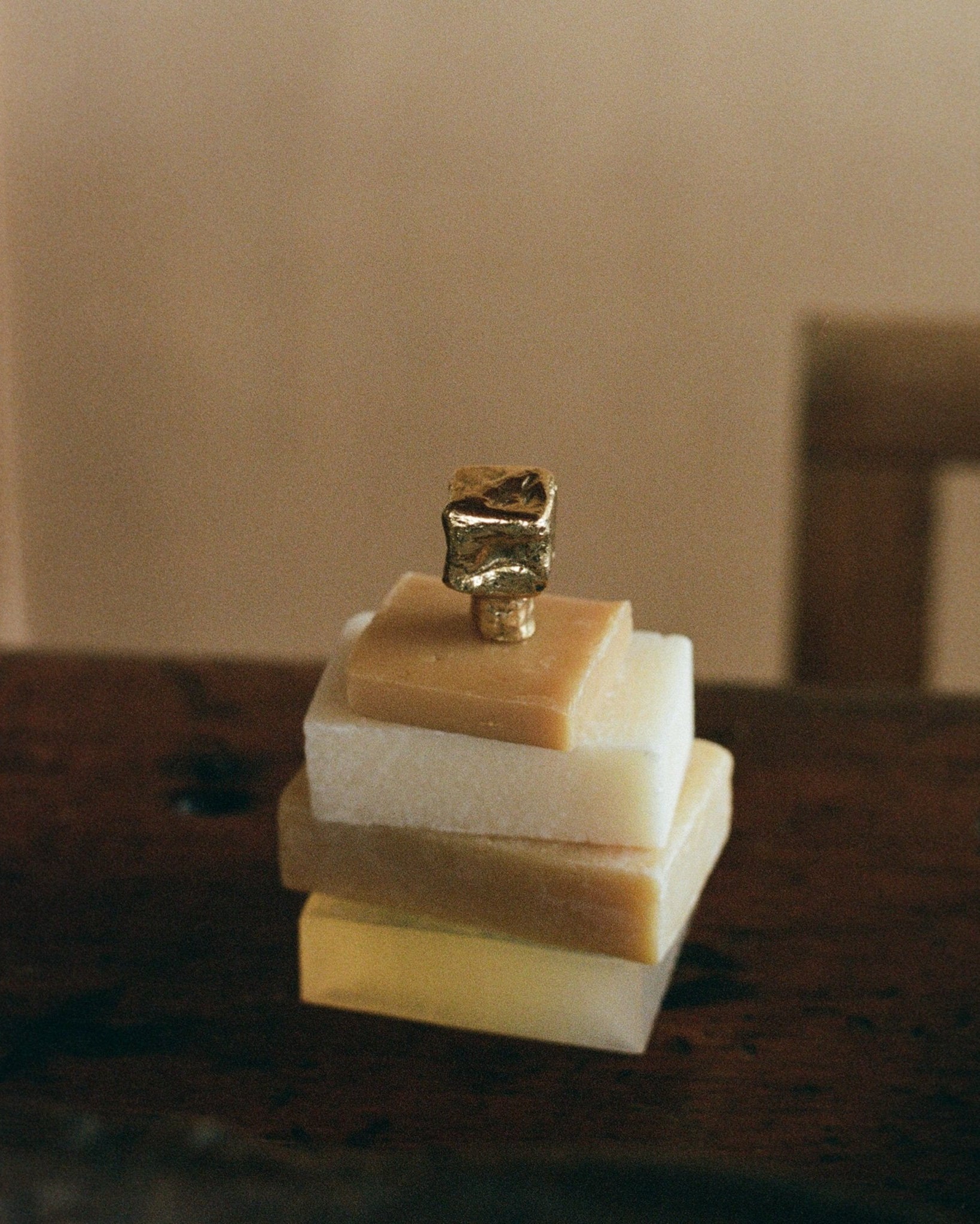 ISLE Cabinet Knob/Wall Hook Small — close-up of gold knob on stacked soap bars