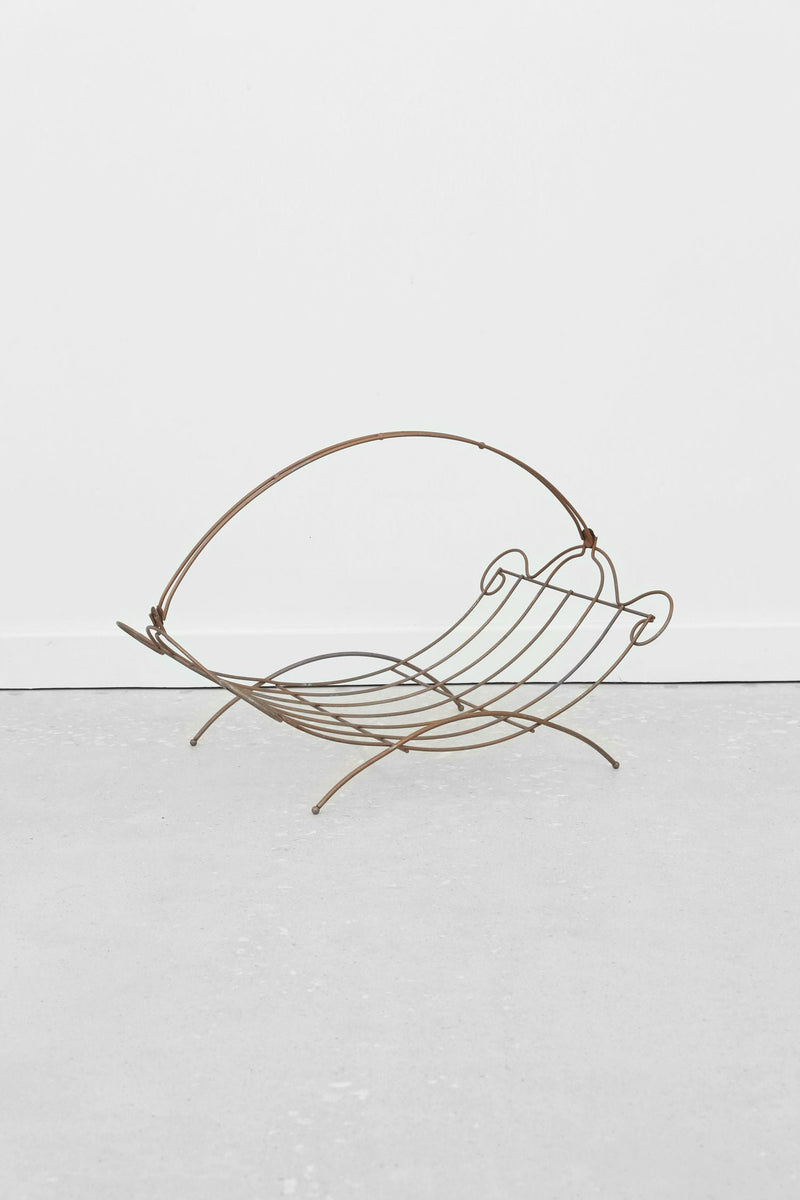Grecian brass magazine rack with curved metal frame profile view