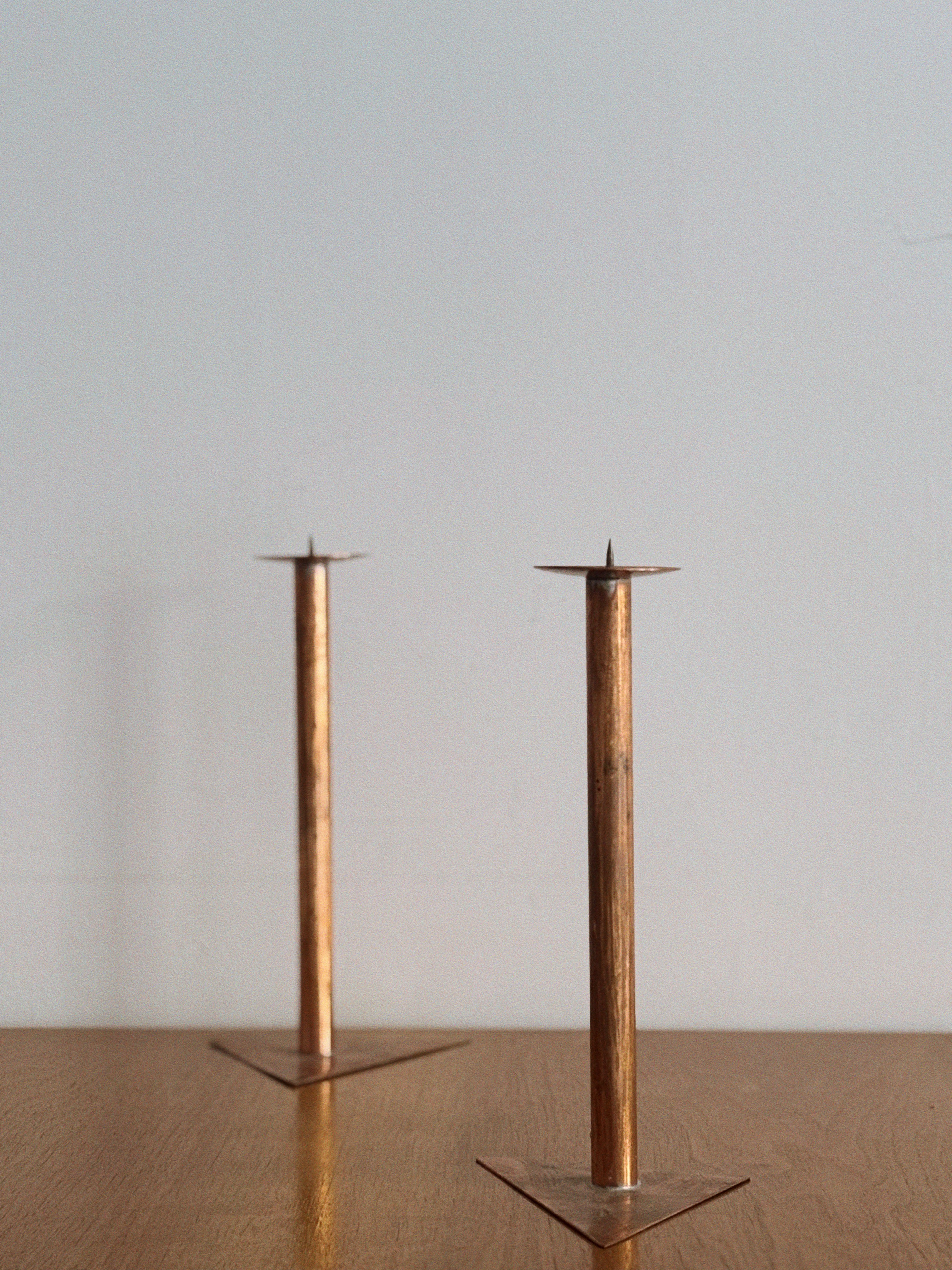 2 Copper Postmodern Candlesticks — top view on wooden table