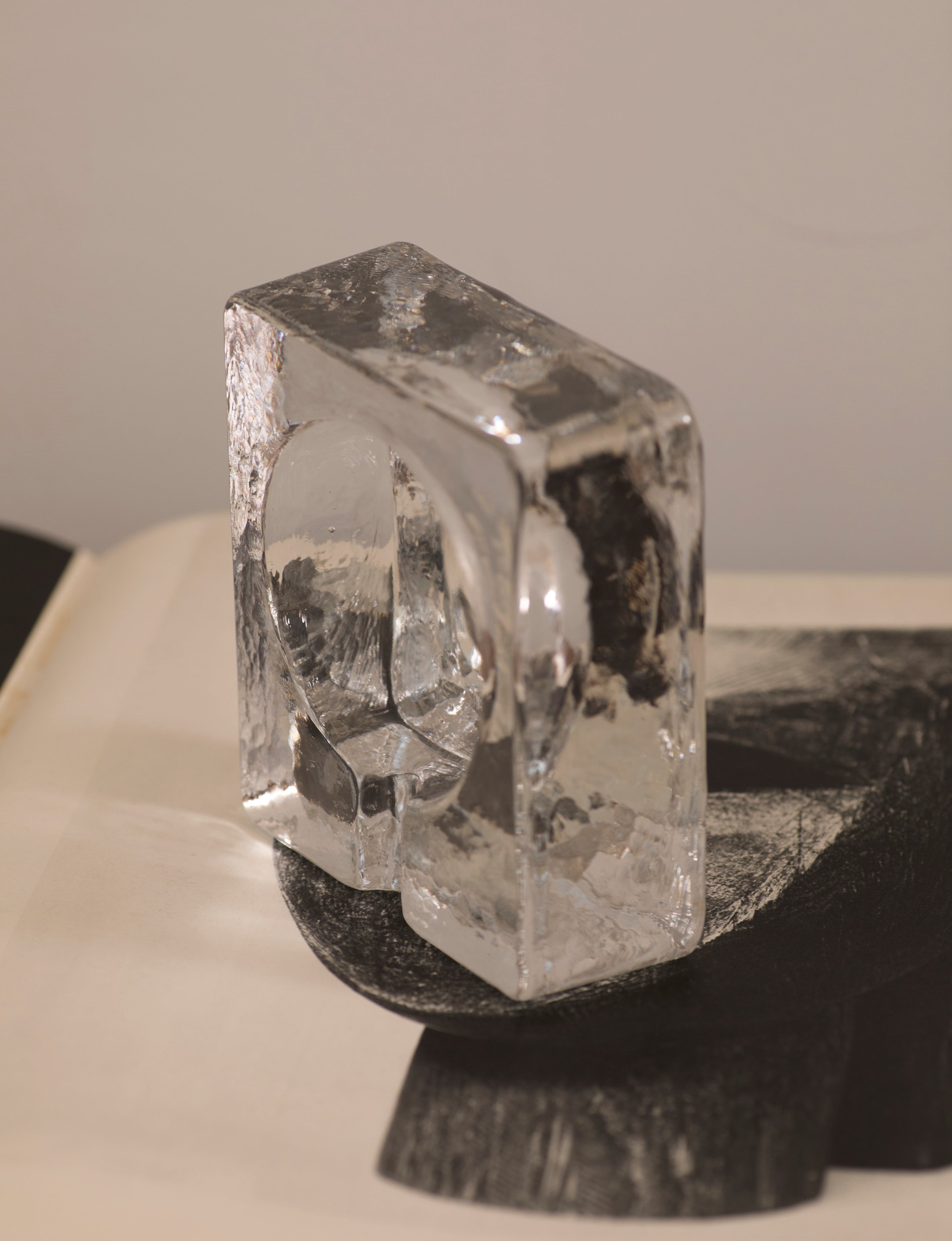 Scandinavian Clear Ashtray in Glass — side angle on textured surface