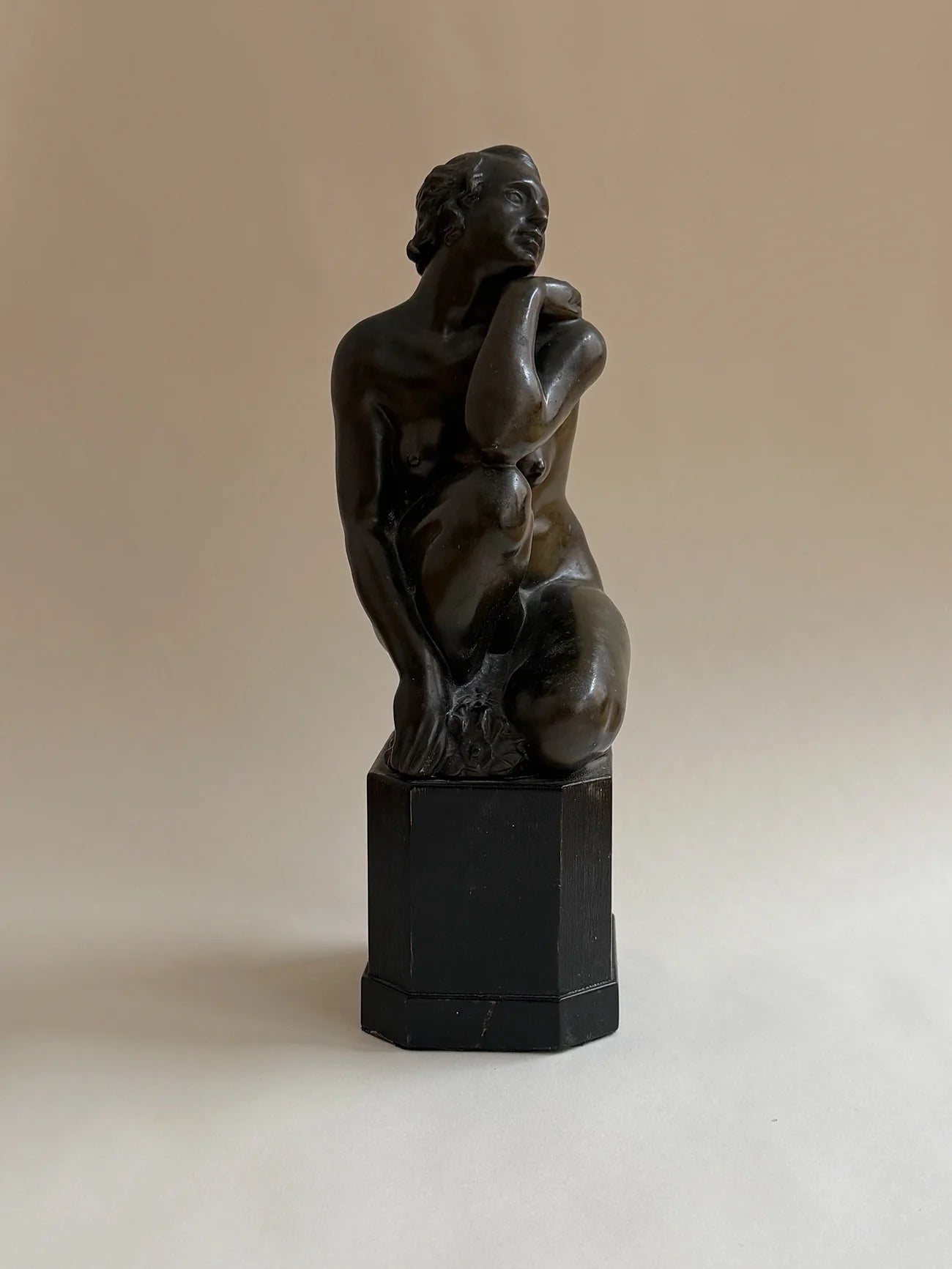 Bronze Sculpture of a Seated Woman — front view on neutral background