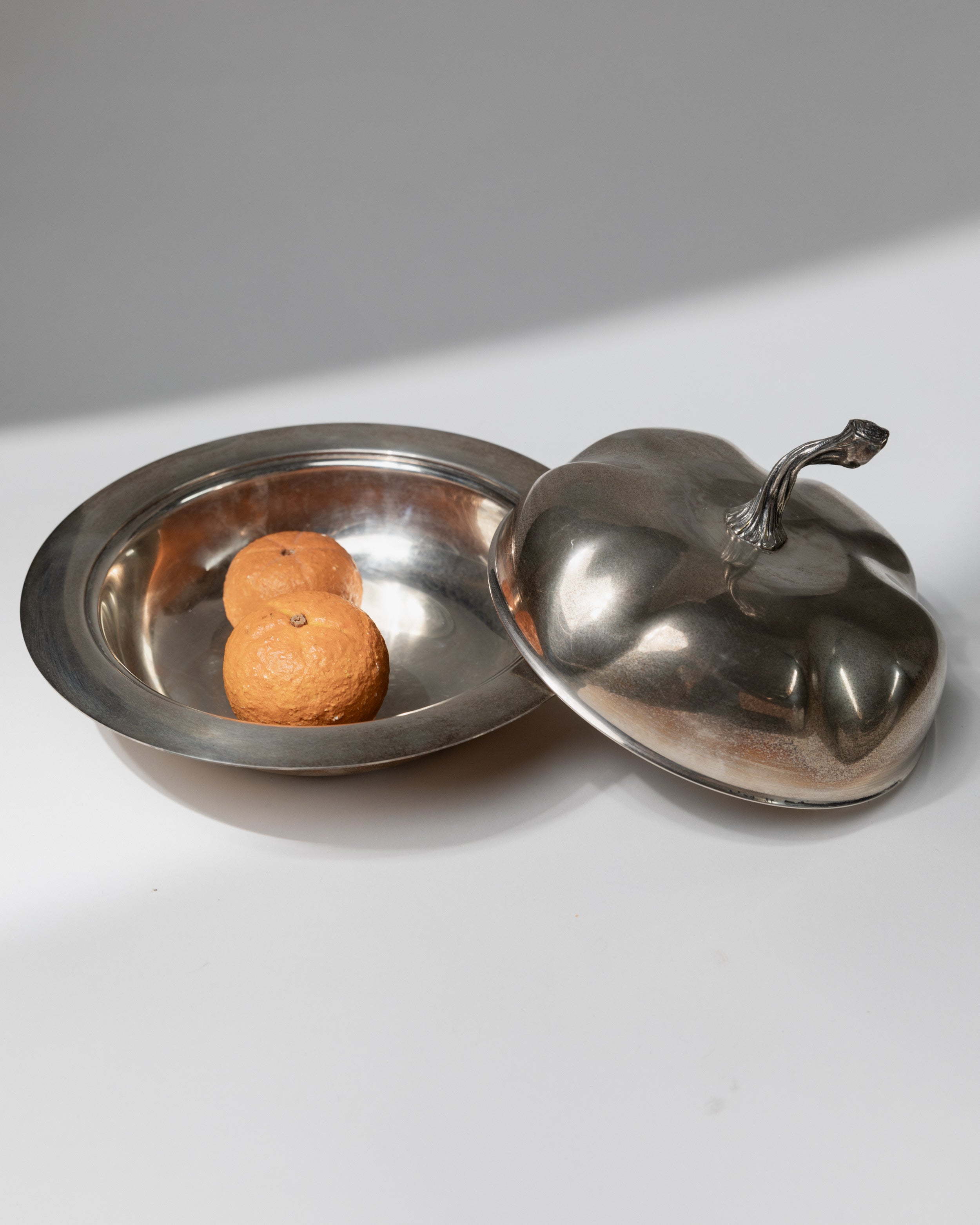 Silver plated serving bowl with ornate lid containing oranges
