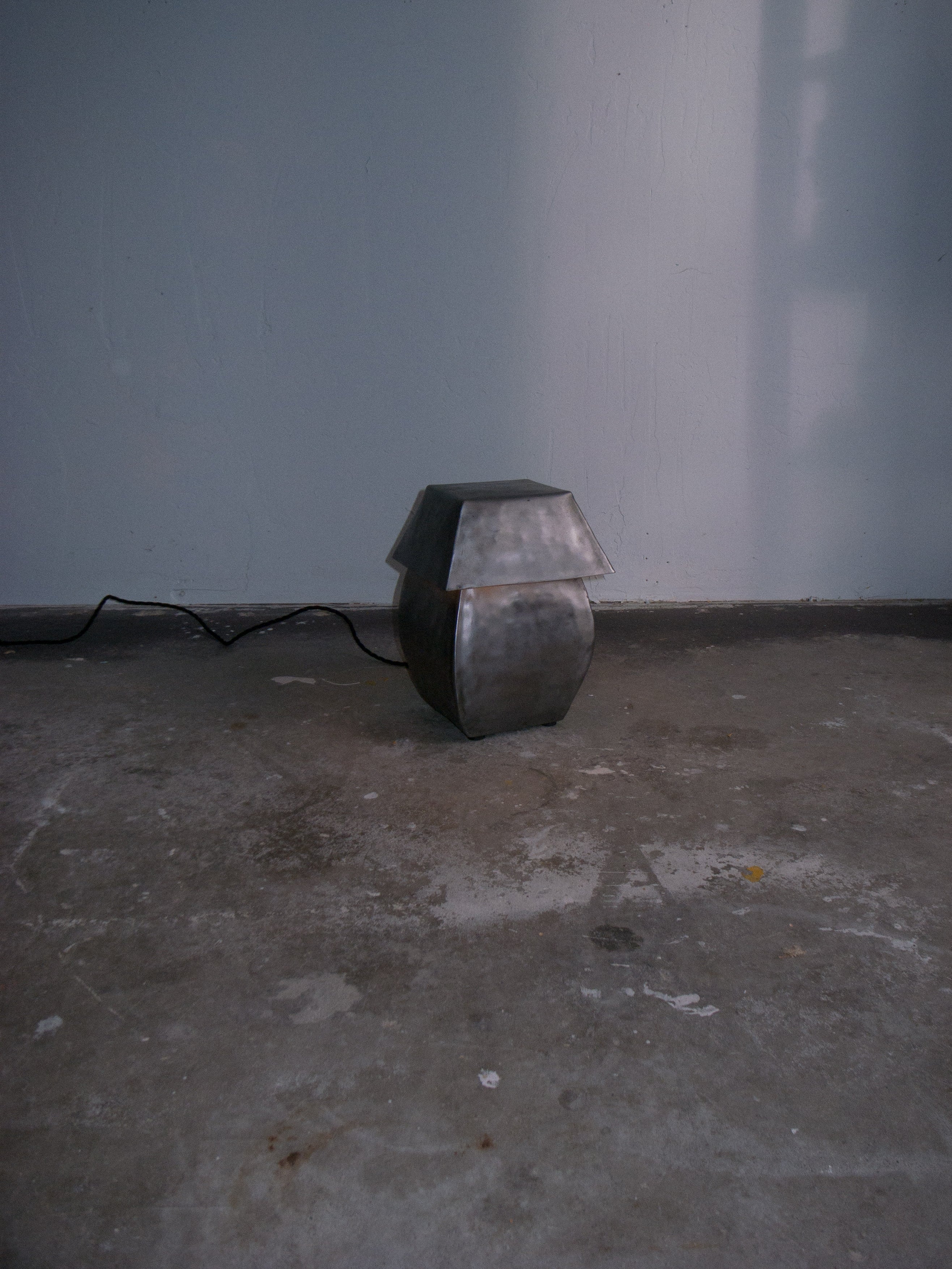 Short hammered steel table lamp by Jesse Butterfield in corner setting