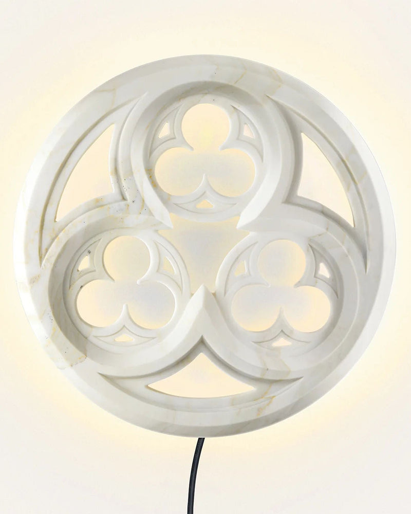 Illuminated tracery wall lamp showing circular stone pattern detail
