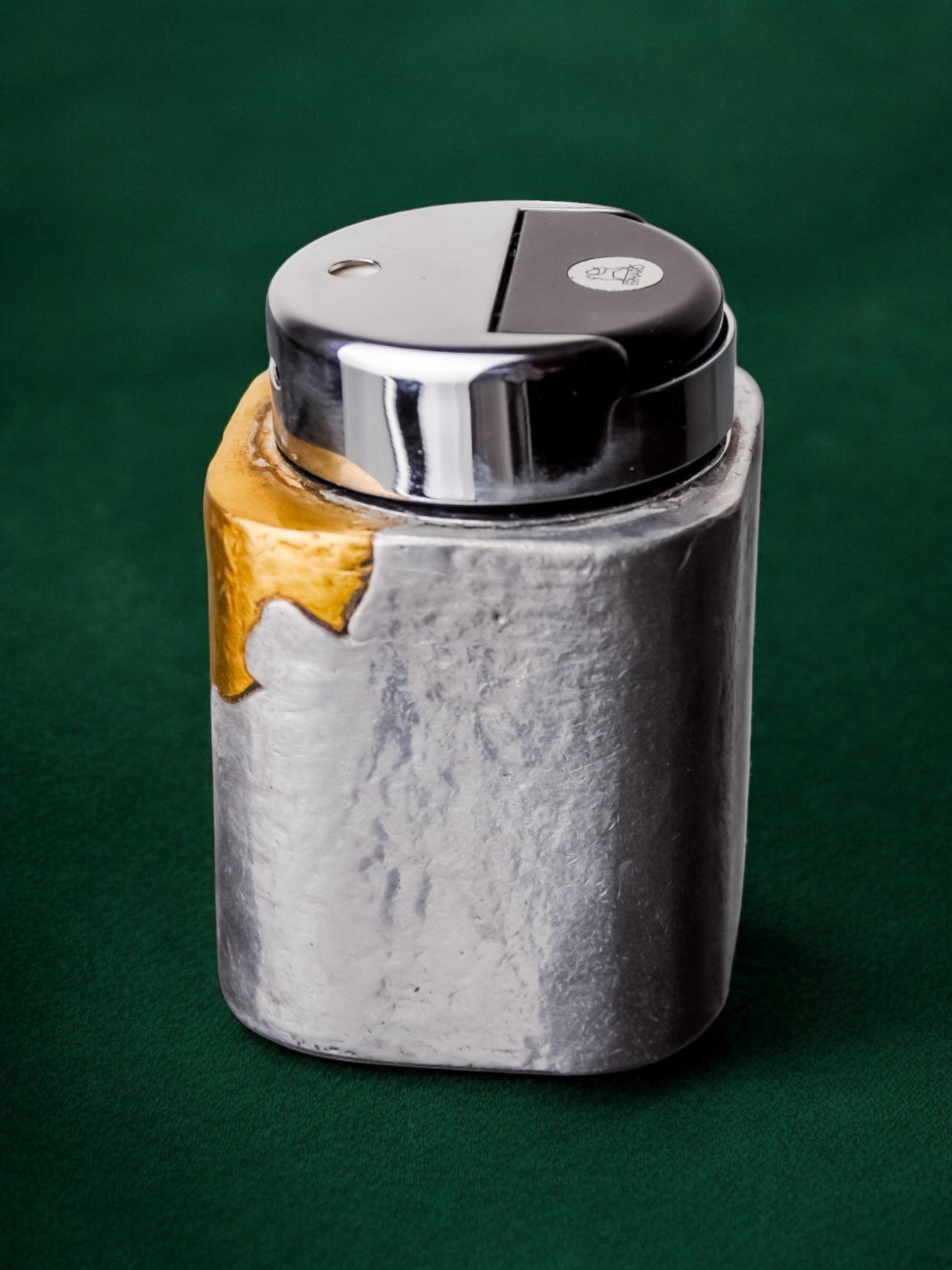 Brutalist lighter by Art3, Brass and aluminum, 1970, Spain — angled view on green background
