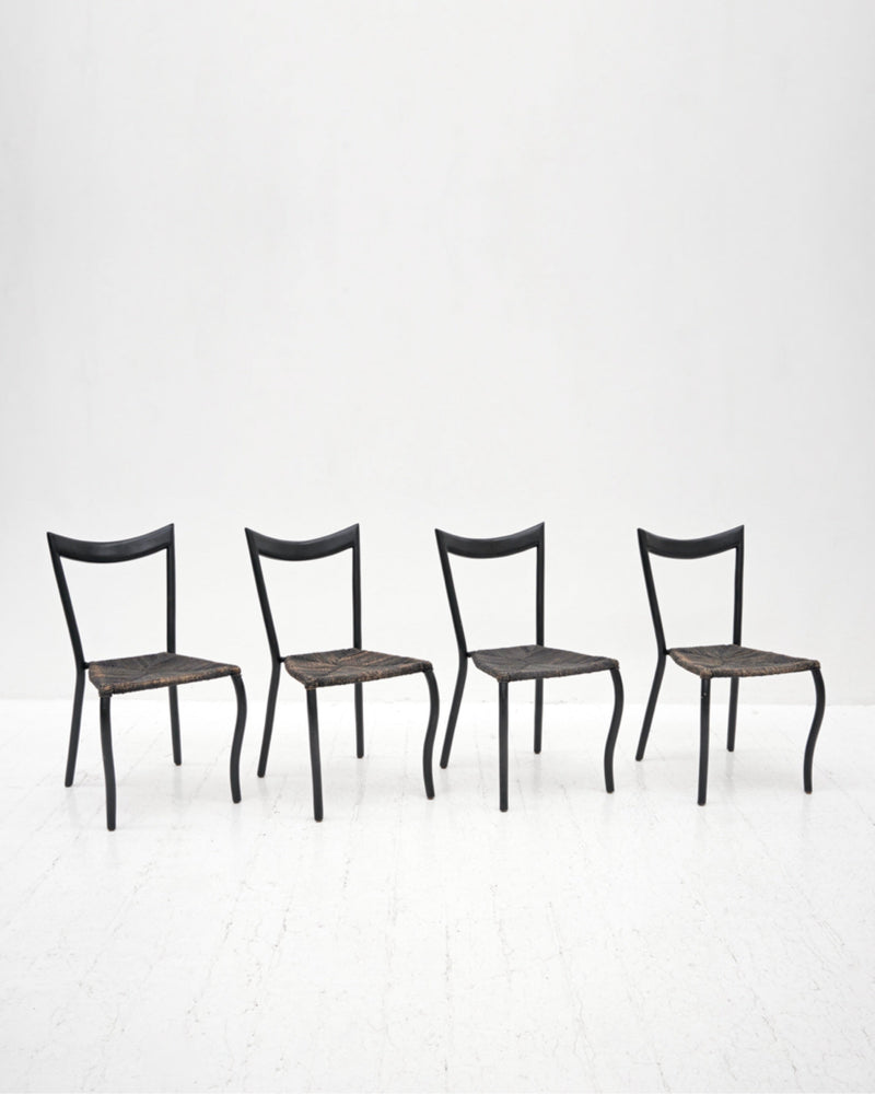 Set of four black Manila dining chairs with woven rush seats