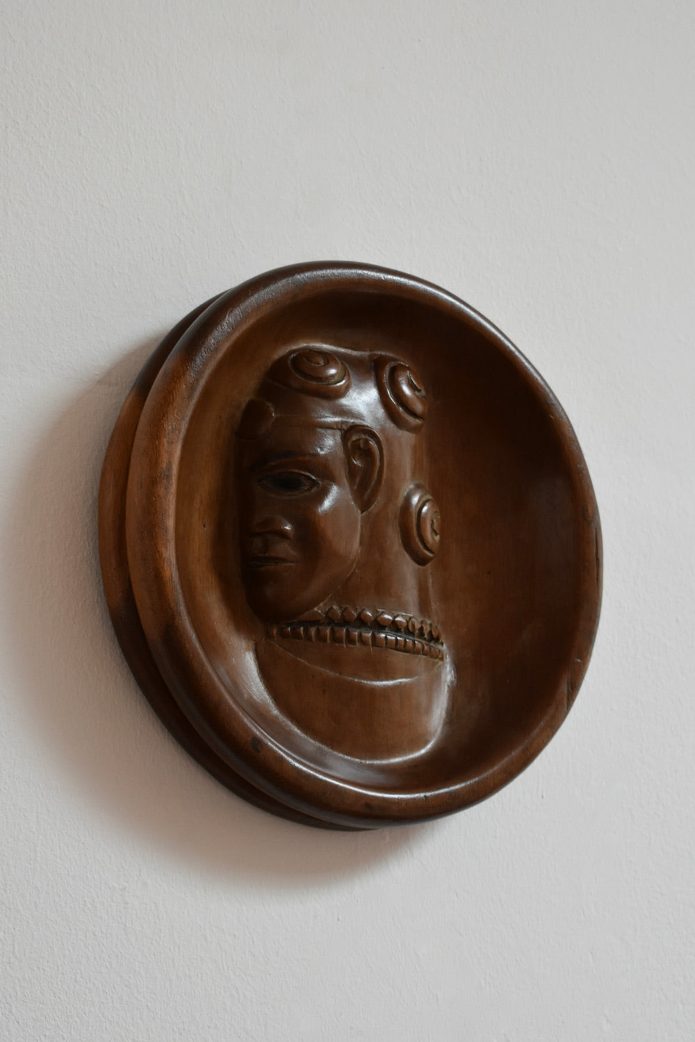 Africanist Low Relief Round Wooden Wall Sculpture — side view highlighting carved wooden face