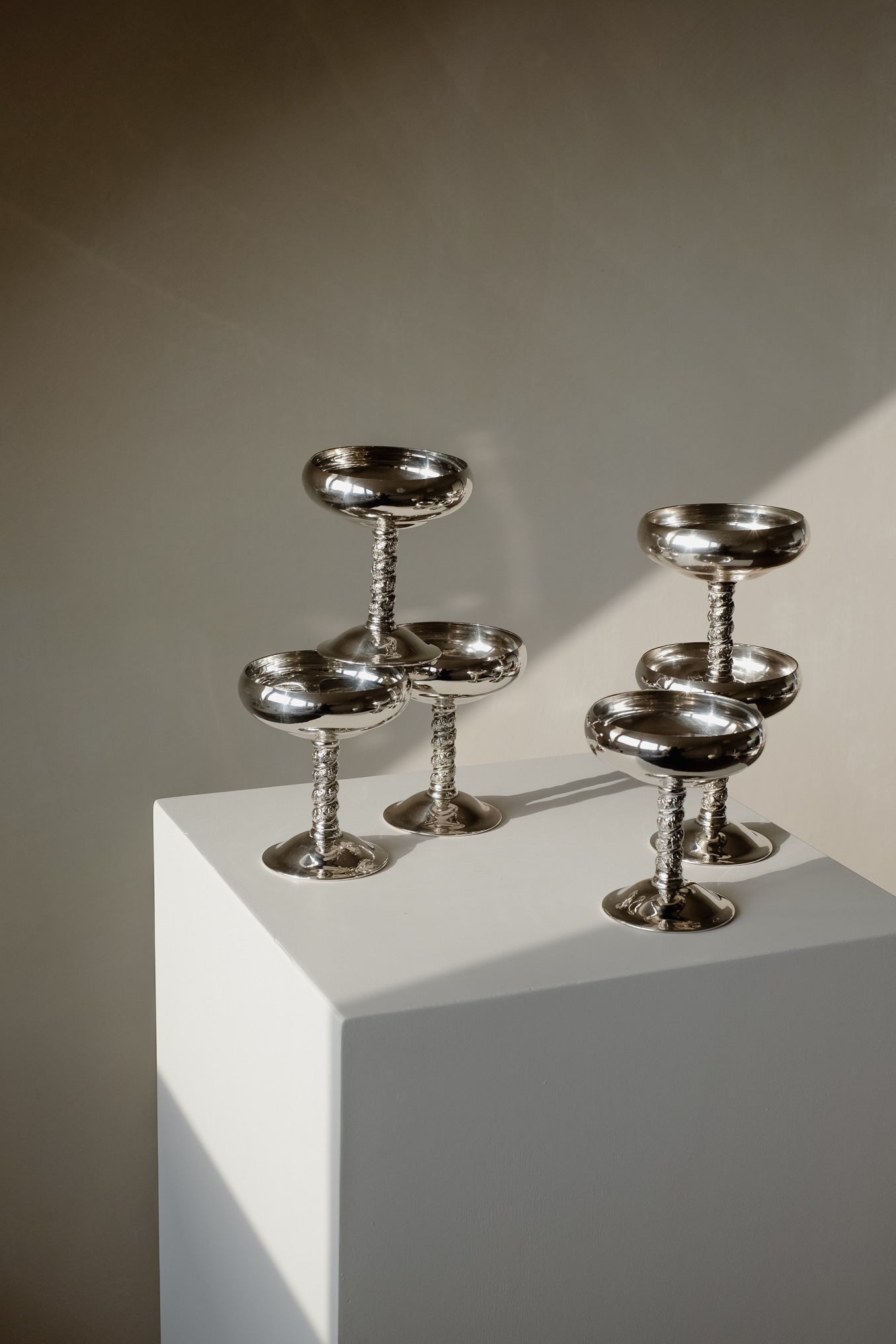 Set of 6 Silver Coupes — angled view on white pedestal with shadow