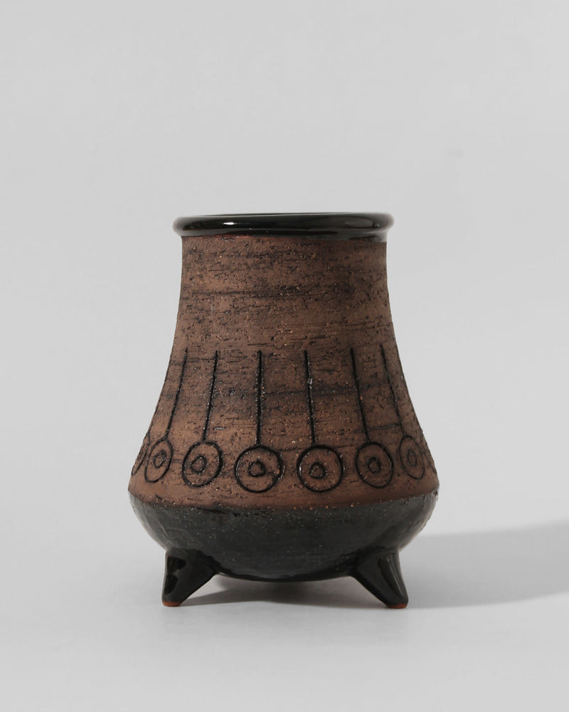 The Eke Bjerén Ceramic Vase On Legs by Vintage Stories for Gabriel Sweden (1960s) features a brown rounded body, flared top, three small legs, black geometric circle patterns, and glossy black rim and base—echoing classic Swedish faience.