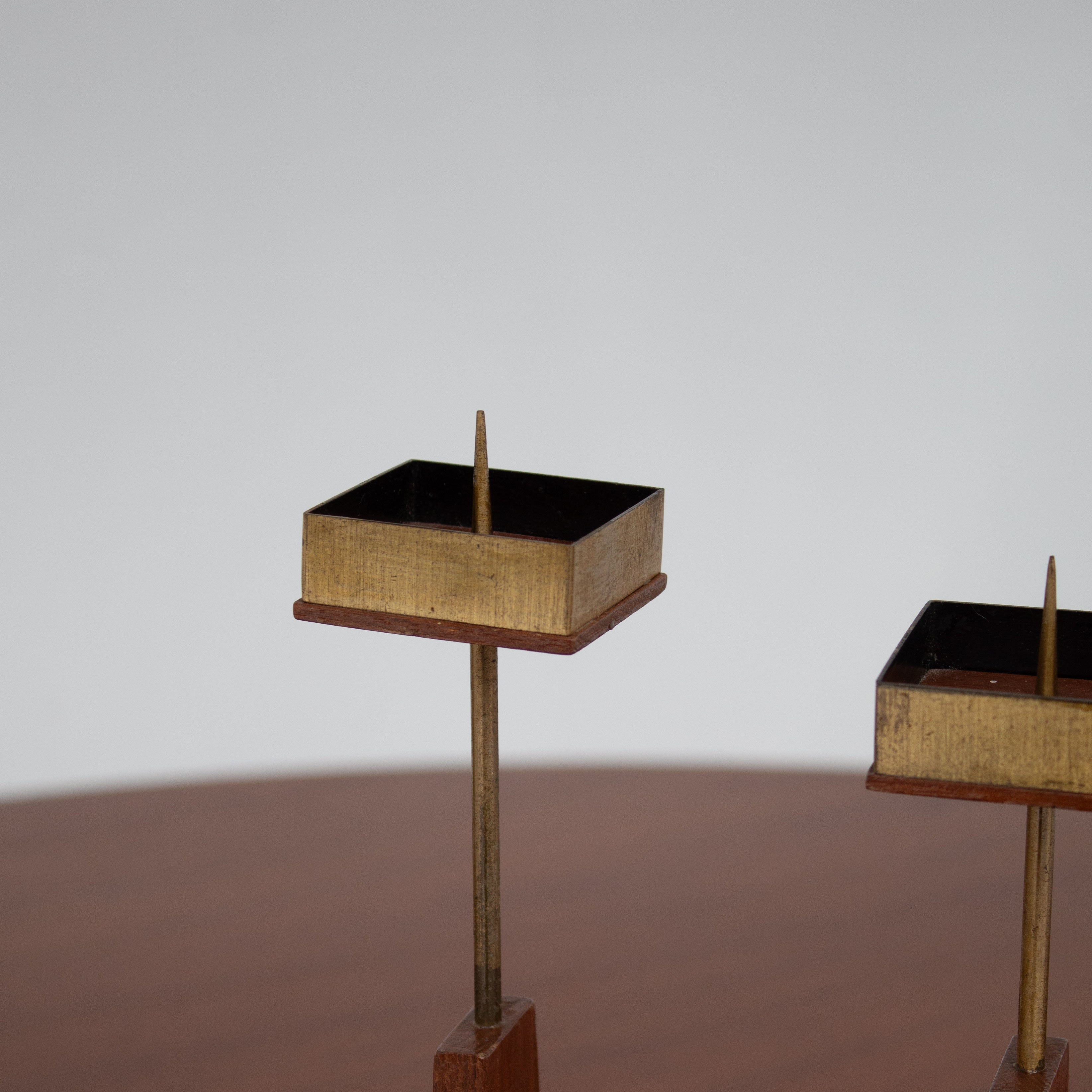 Vintage Candle Holders in Wood / Teak — close-up of brass candle holders on wooden surface