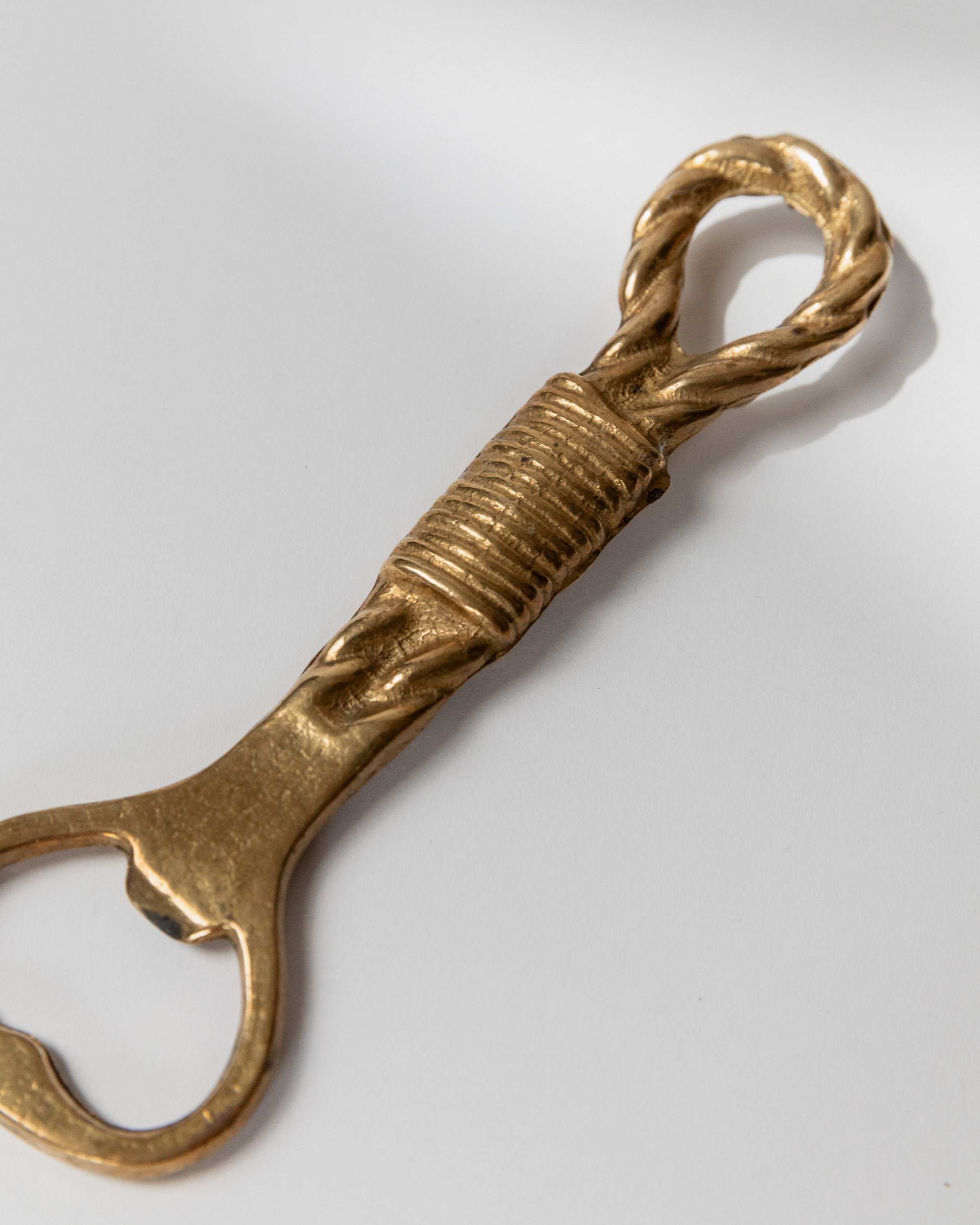 Twisted brass bottle opener handle detail showing rope-like texture