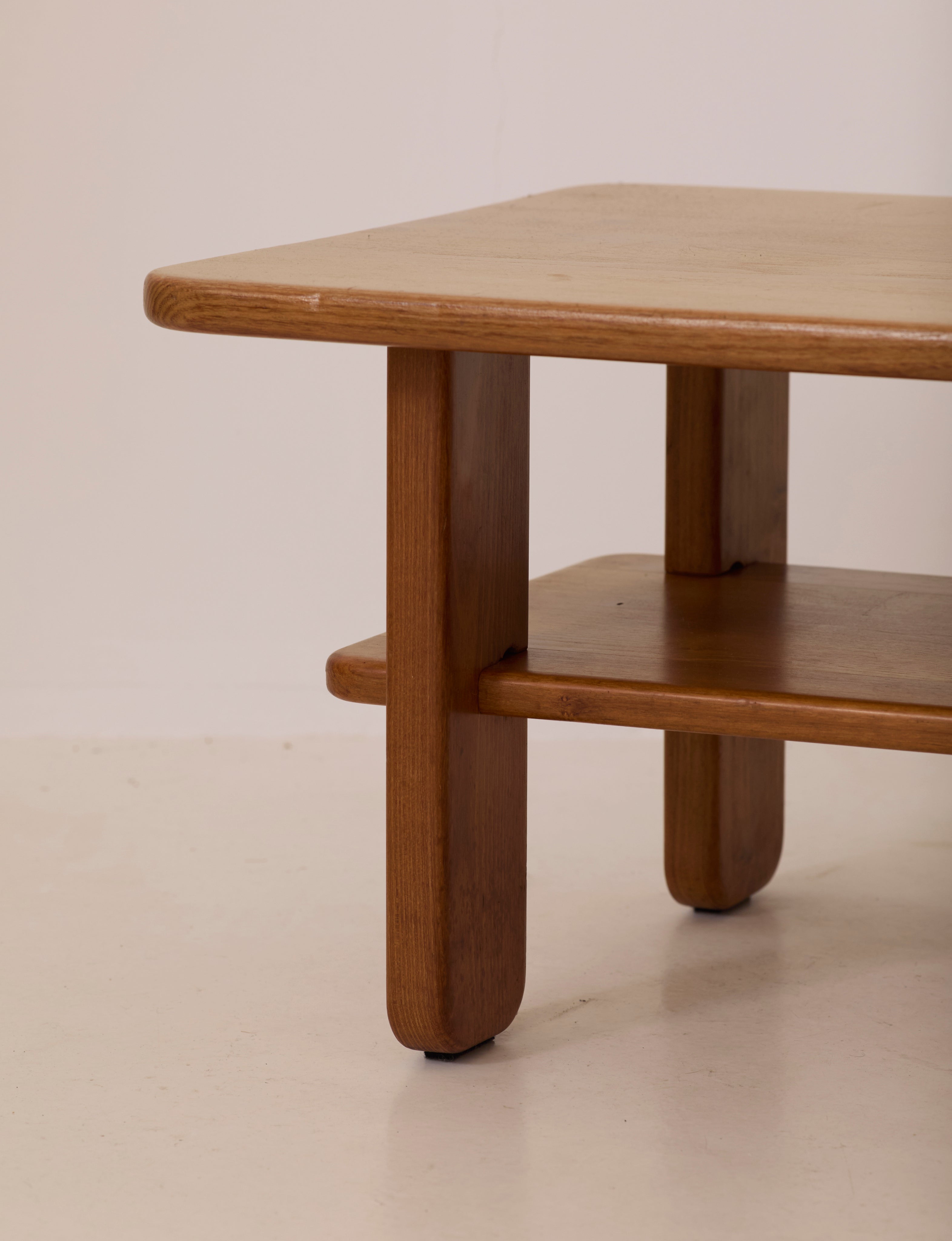 Solid elm coffee table by Alain Gaubert, France circa 1980 — angled view highlighting round legs and lower shelf
