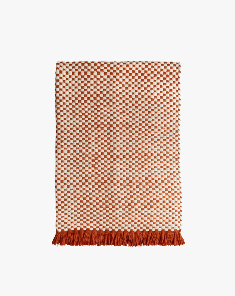 Damier Throw - Red — close-up of woven red and cream fabric