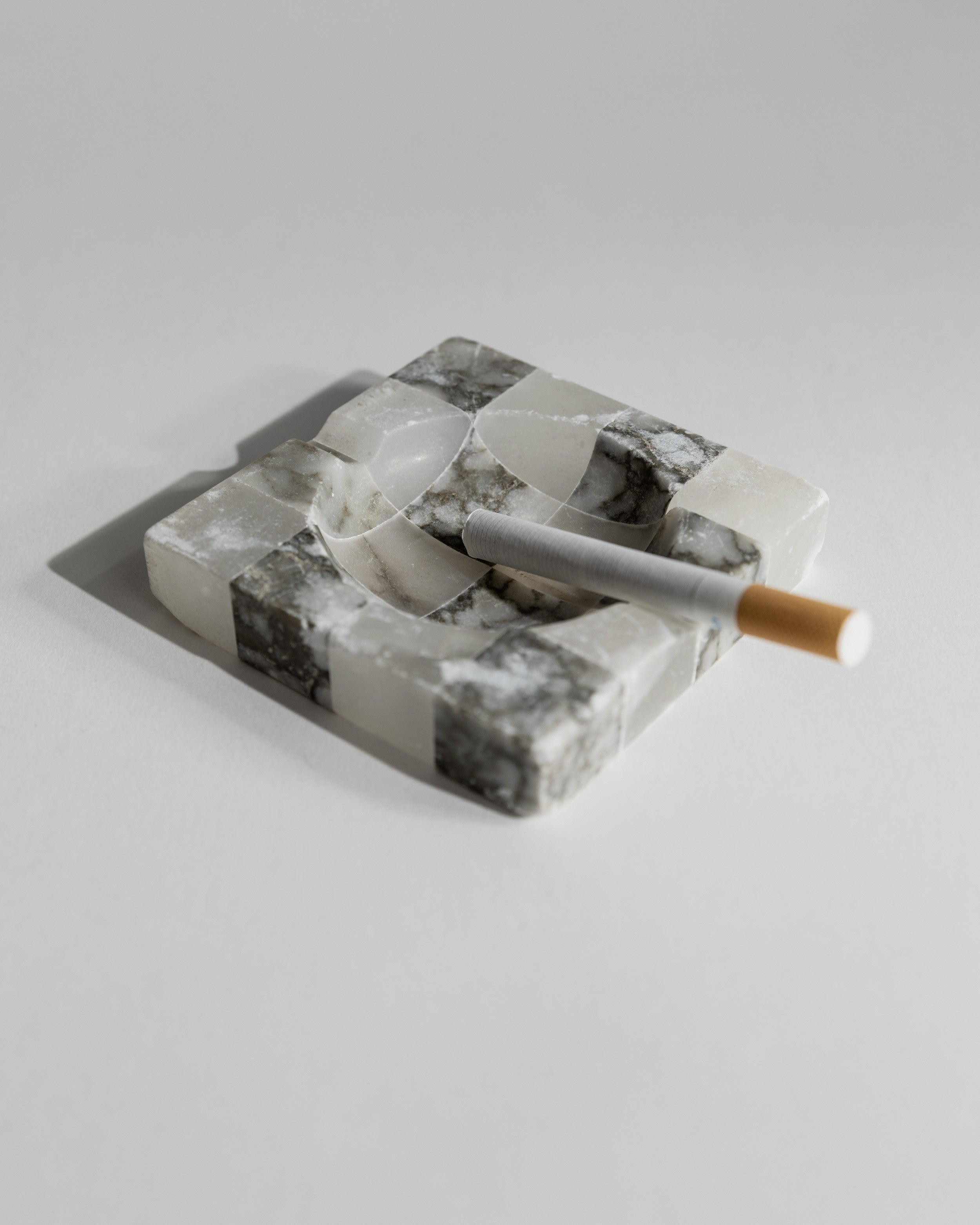 1970s marble ashtray with cigarette, white and grey veined stone