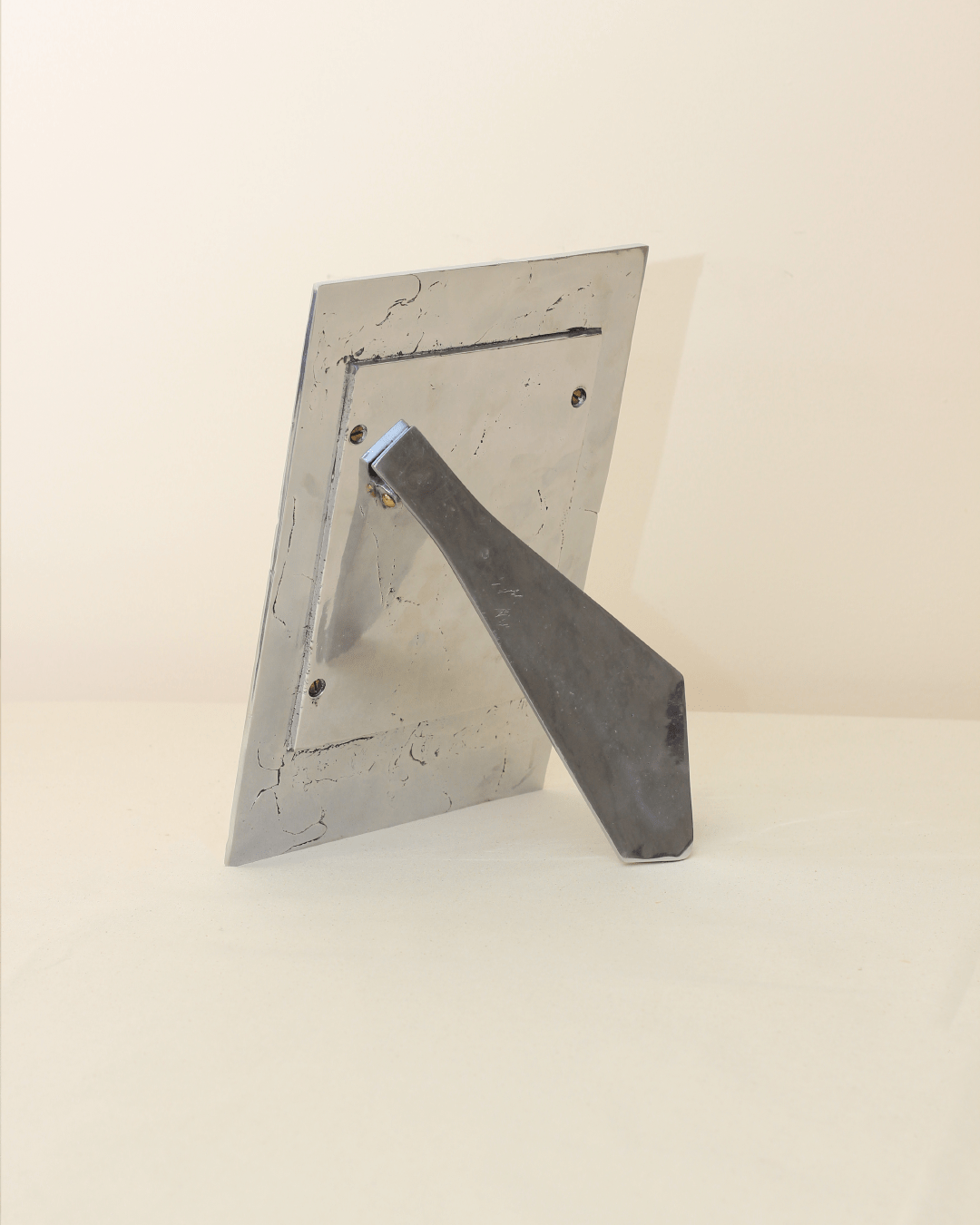 Porta Retrato Brutalista — angled view of metal frame on table