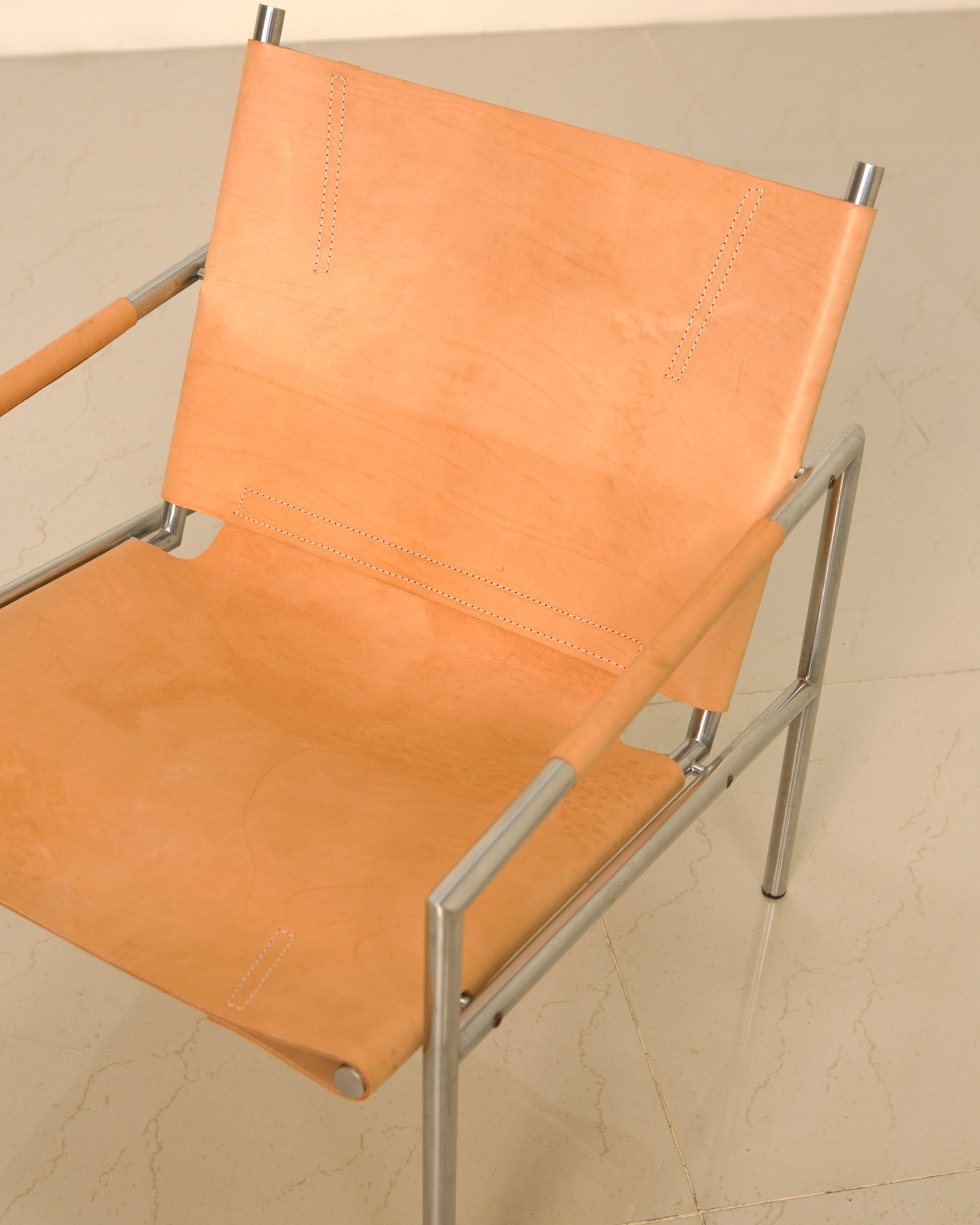 Orange leather SZ02 armchair detail showing stitched seams and chrome frame