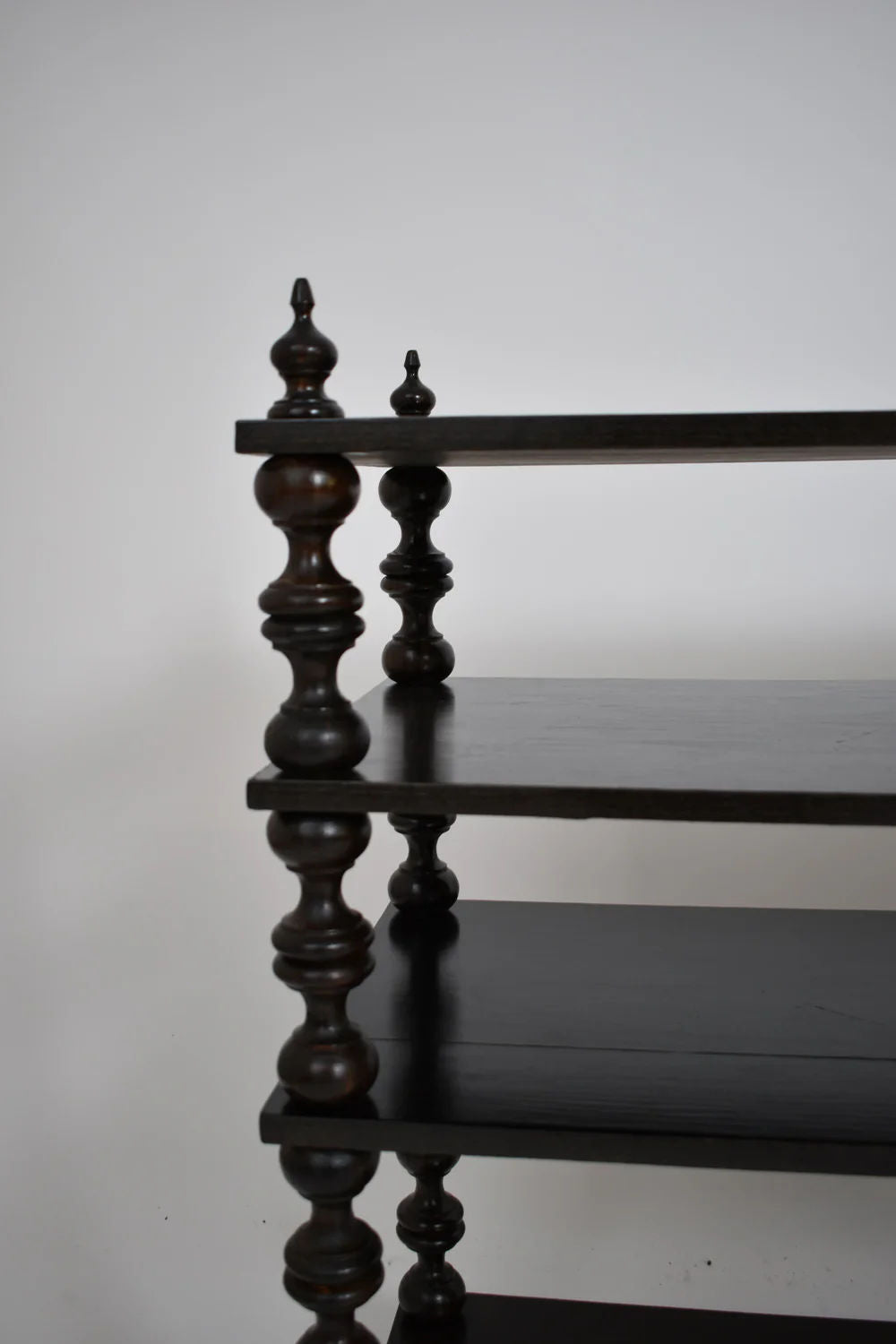 A close-up of the Ebonised Turned Wood Bookshelves Console by Barracuda Interiors displays three flat shelves with ornate supports, showcasing 1950s elegance against a plain white background.
