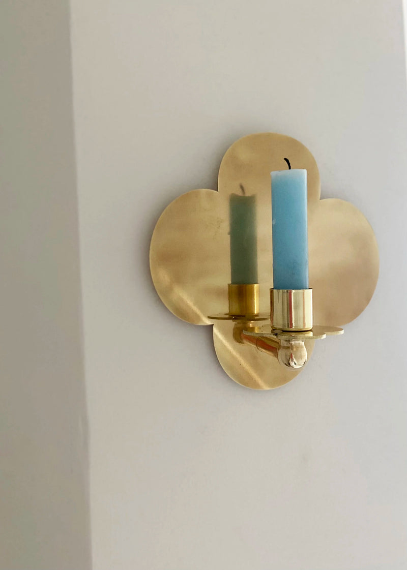 Quatrefoil Candle Sconce D:2023 — close-up of brass sconce with blue candles