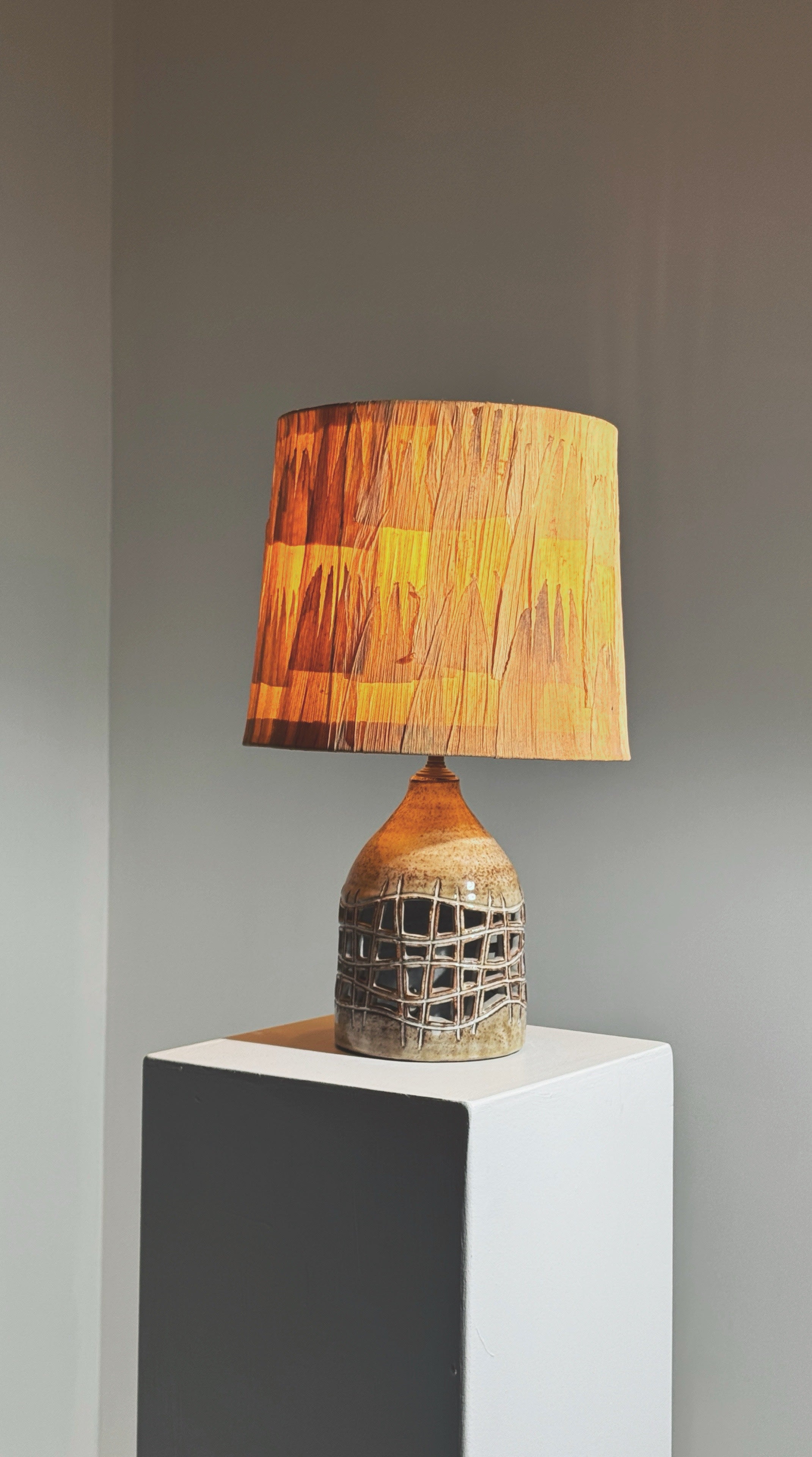Elegant pierced lamp by Robert Pérot, Vallauris, France, circa 1960 — displayed on white pedestal with warm light