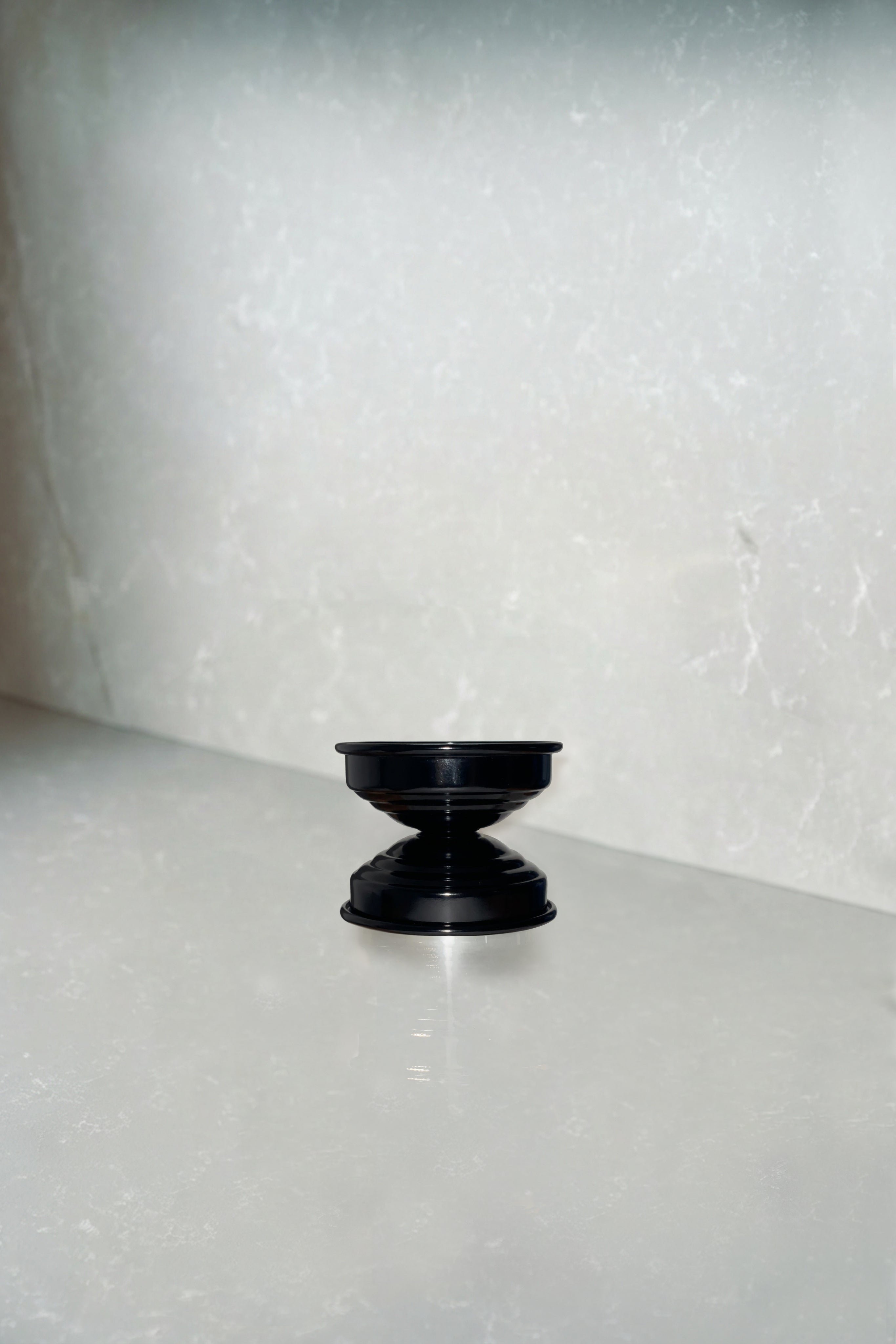 Contemporary Classic Candle Holders in Metal - Licorice Black Collection — angled view on light marble surface