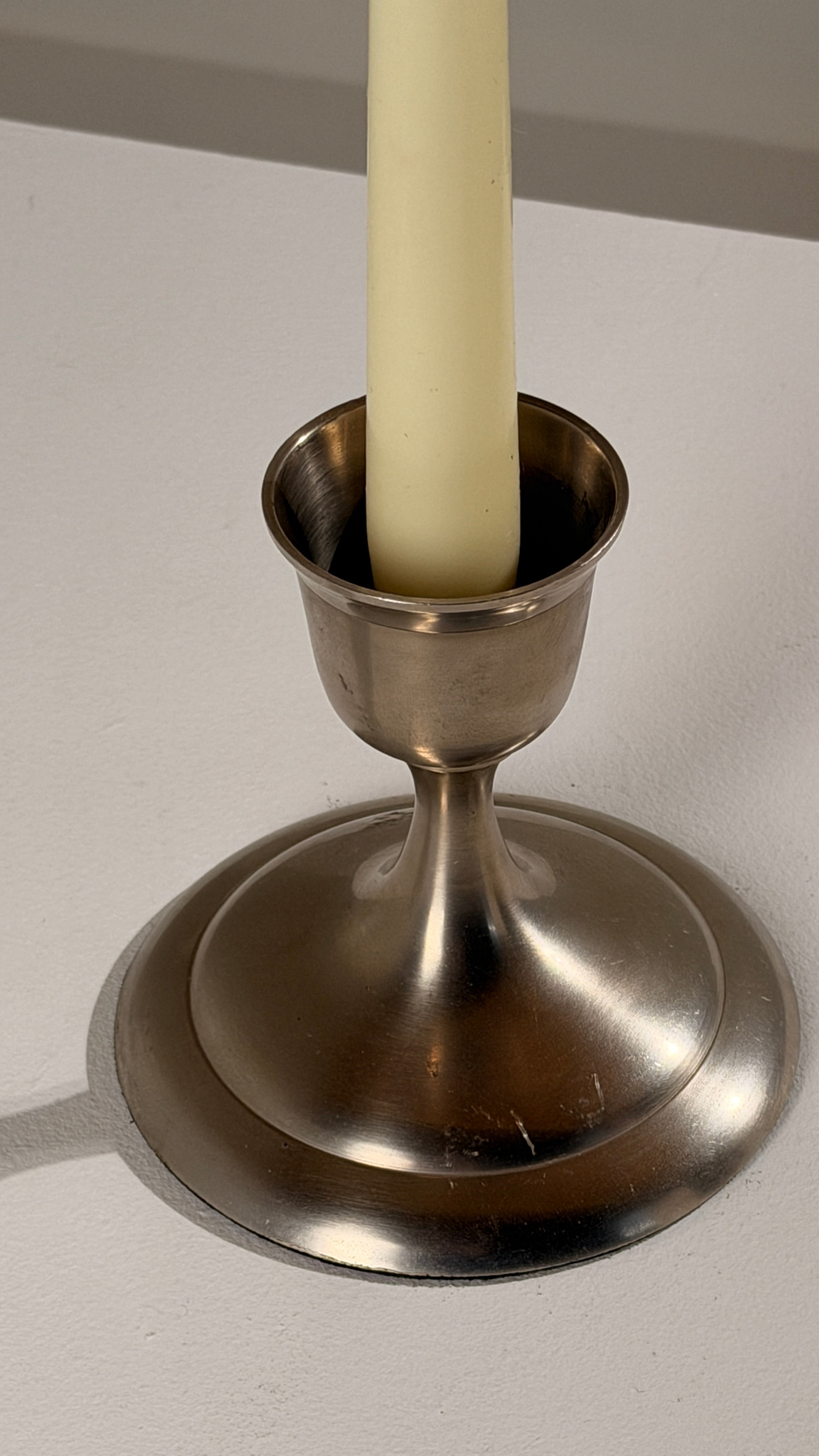 Silver-plated Metal Candleholders, France, circa 1930 — close-up of candleholder base on white surface