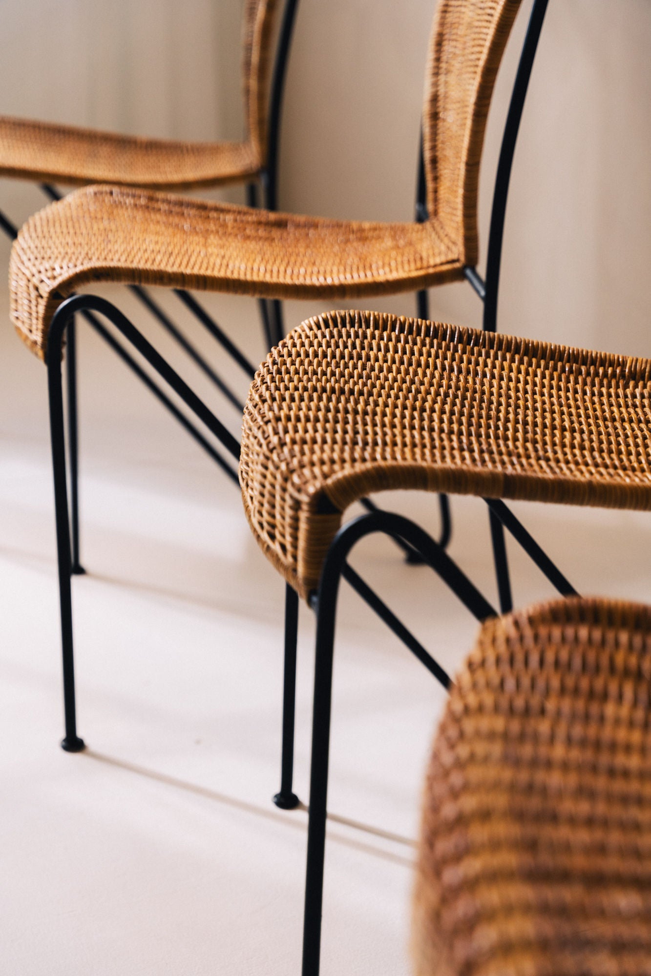 Detail view of woven rattan seats on 1950s Frederic Weinberg chairs