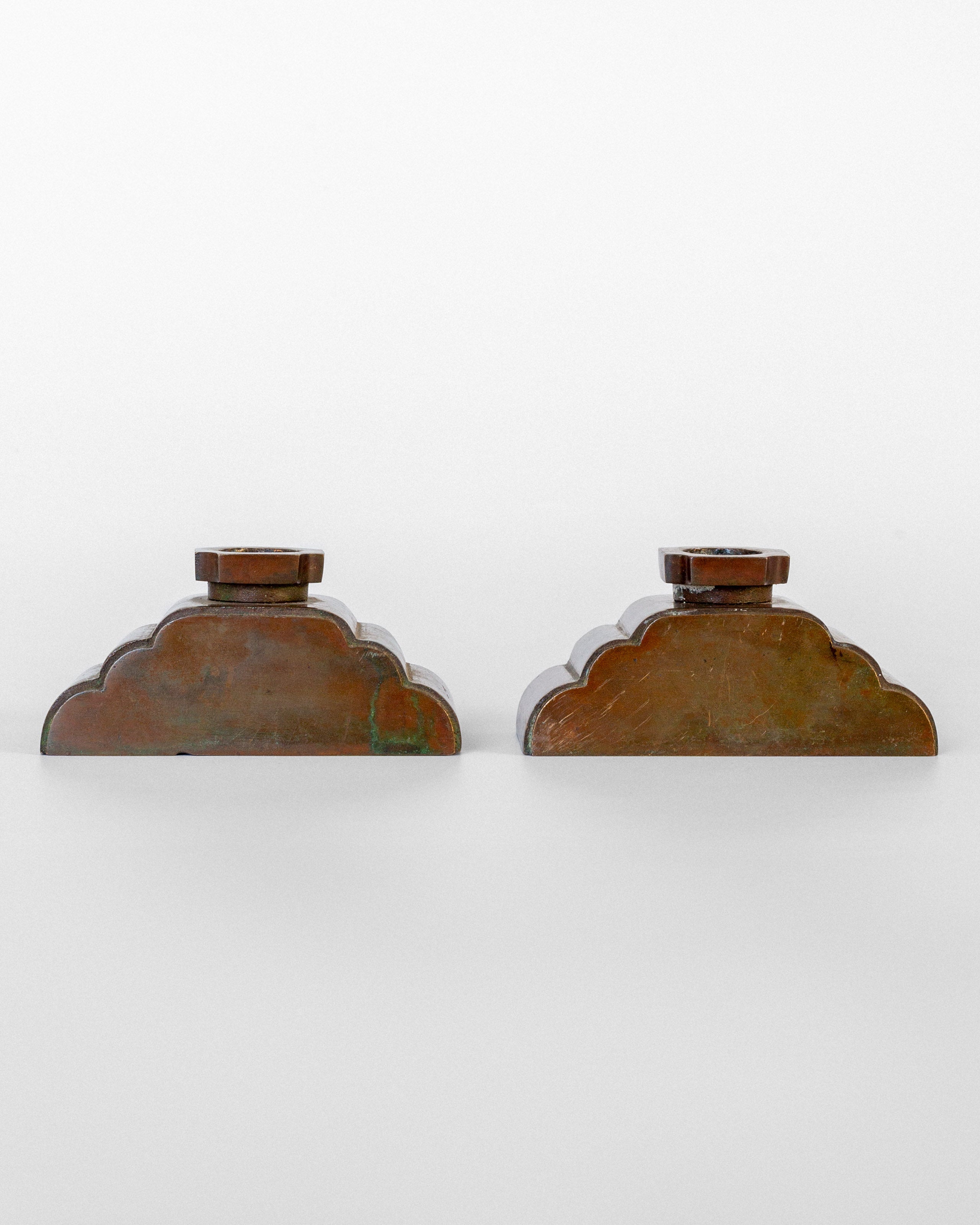 Bronze candleholders back view showing patina and scalloped edges