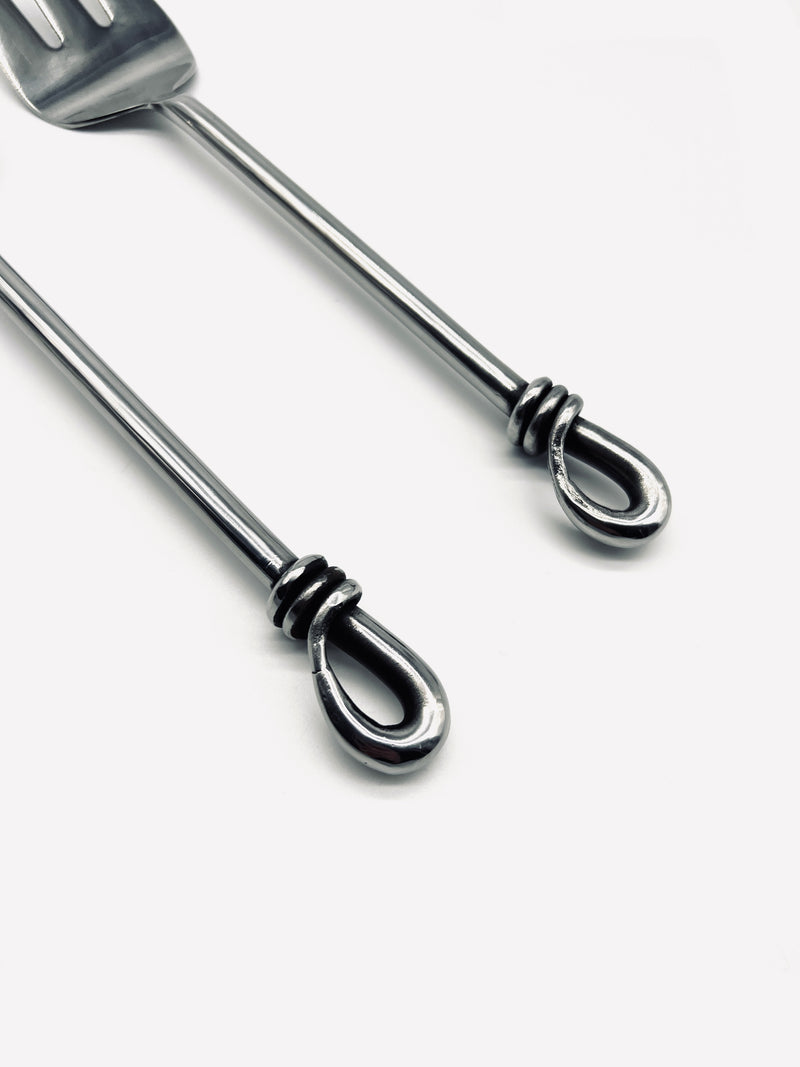 Detail view of stainless steel salad servers with teardrop ends