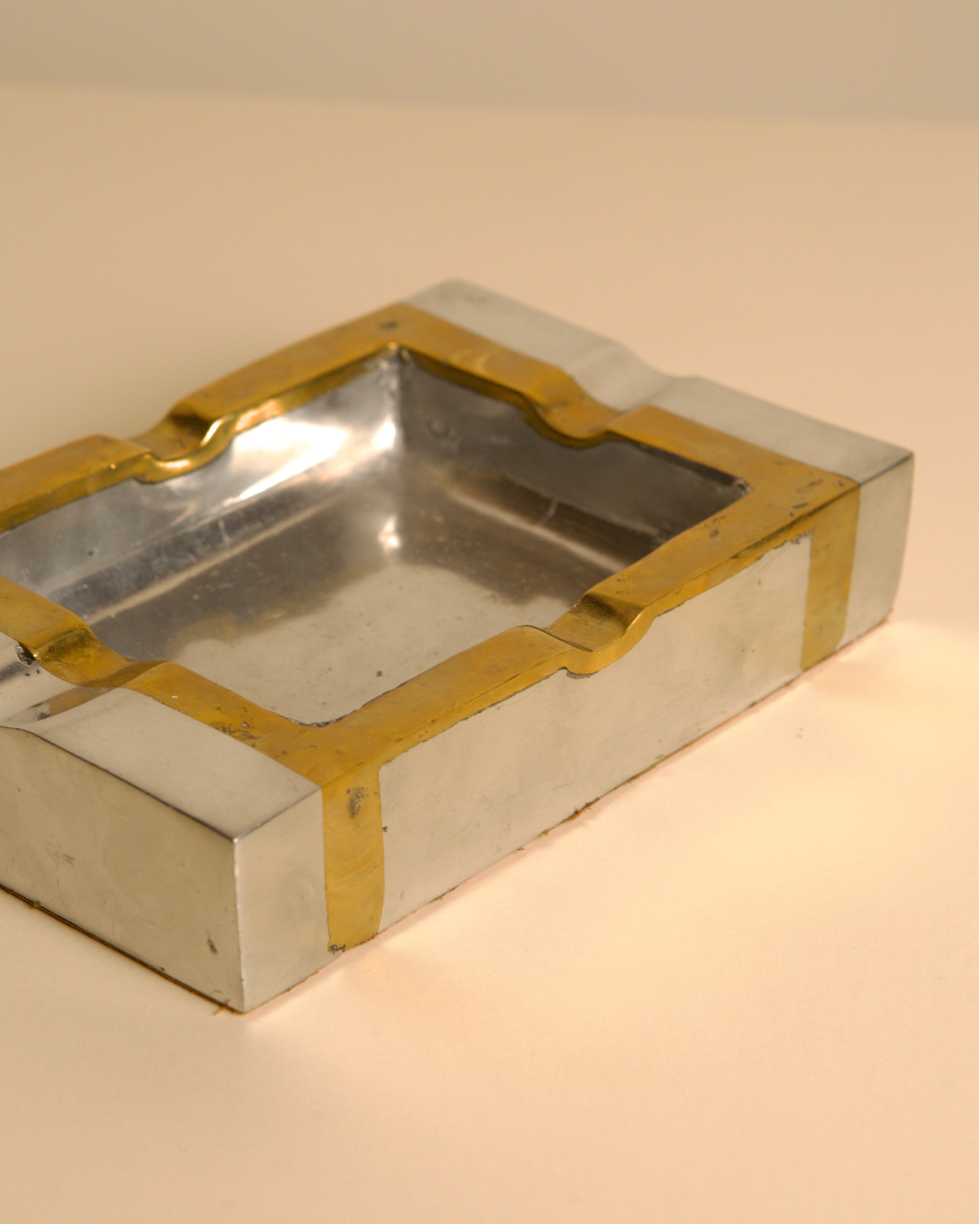 Brutalist brass and silver ashtray detail showing geometric form