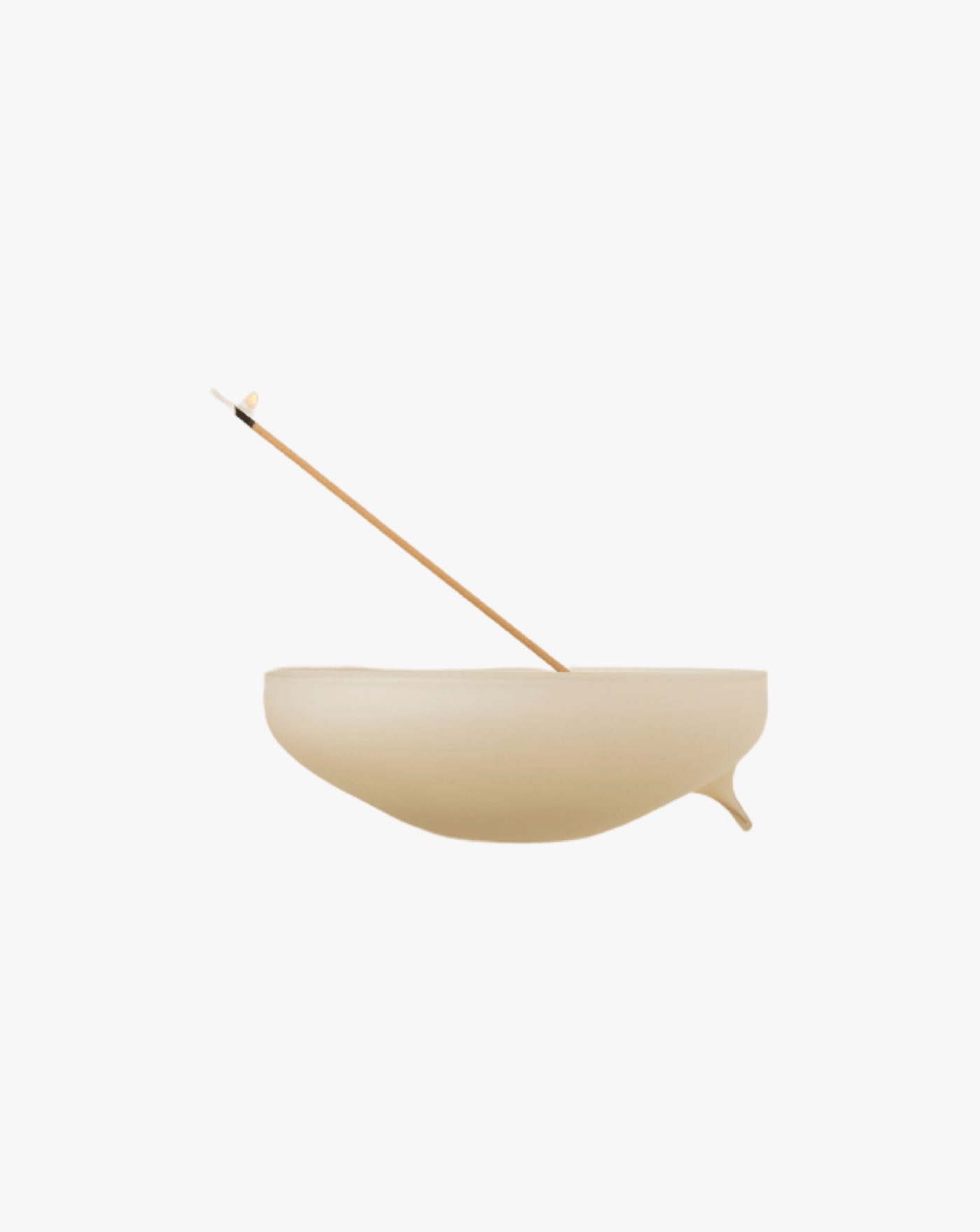 A minimalist image of a Los Objetos Decorativos ecru incense holder with a single thin stick of incense, balancing diagonally, all against a plain white background.