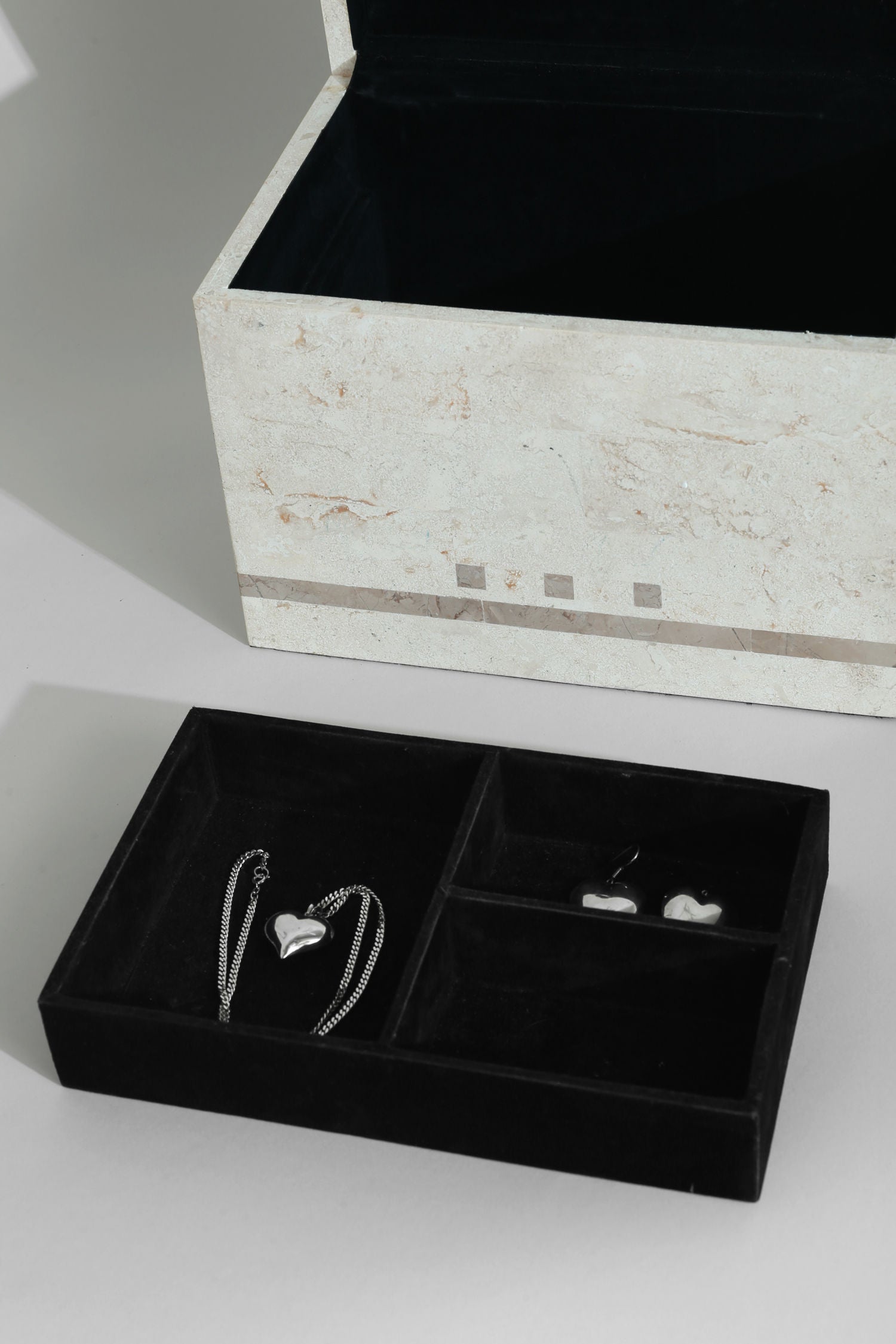 Tessellated stone jewelry box interior compartments with silver necklace