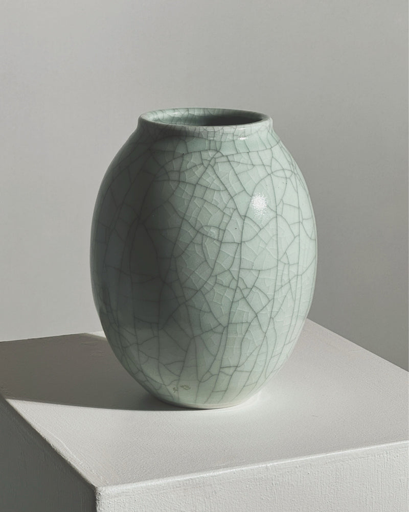 Celadon crackle-glazed ceramic vase with organic oval form