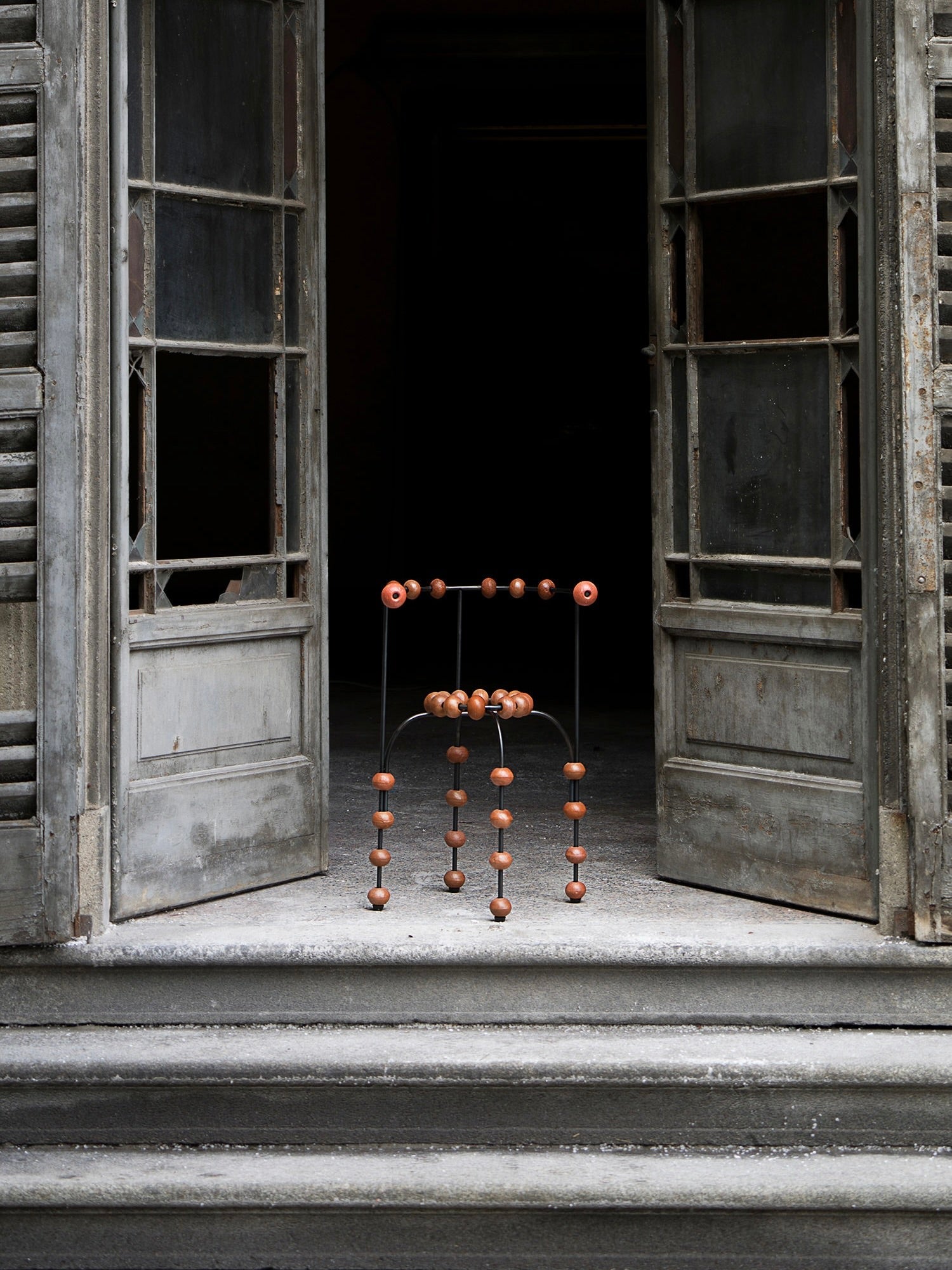 The "Buoys" Chair — positioned at open doorway with wooden beads