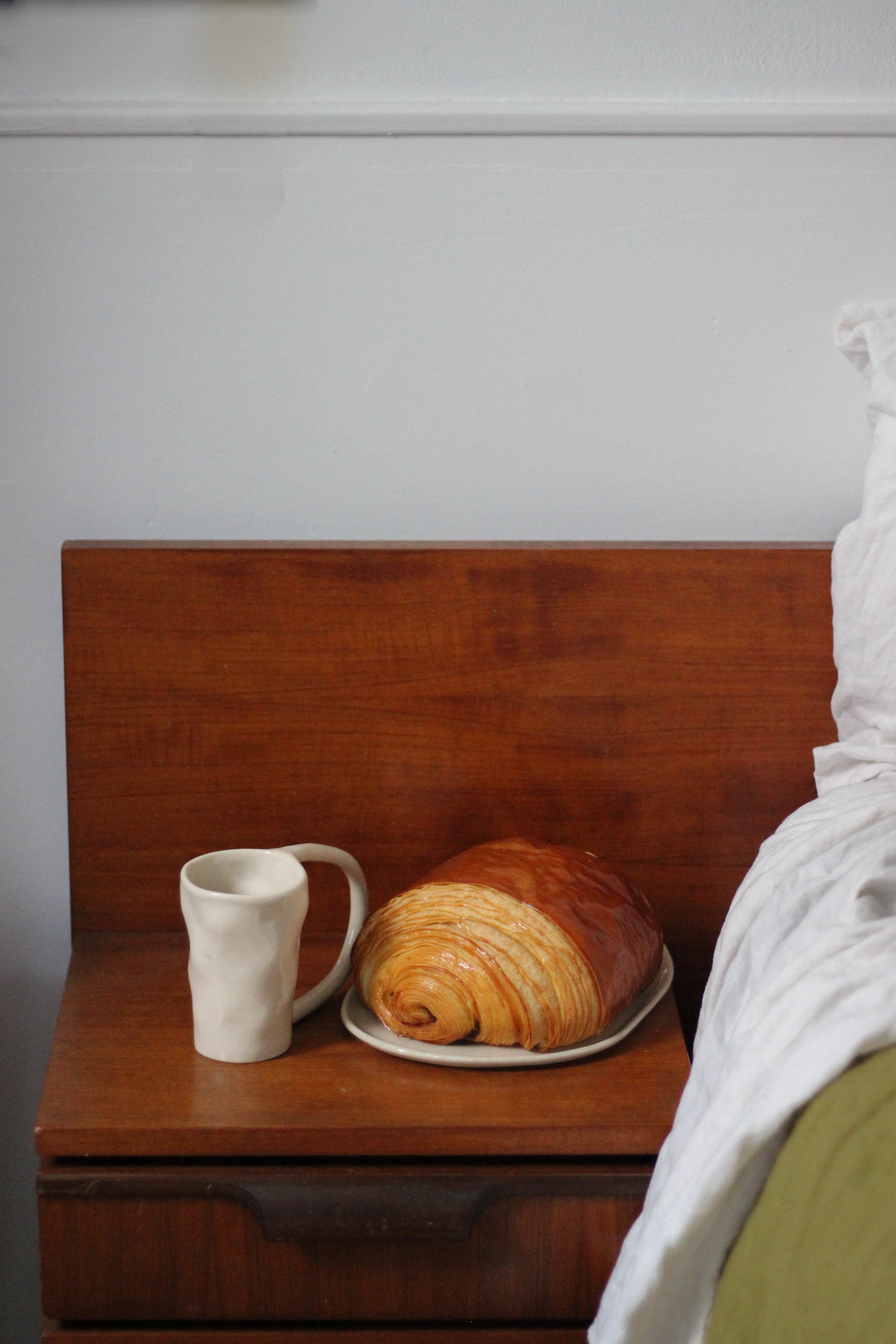 Large Stoneware Coffee Mug — placed on wooden nightstand with croissant