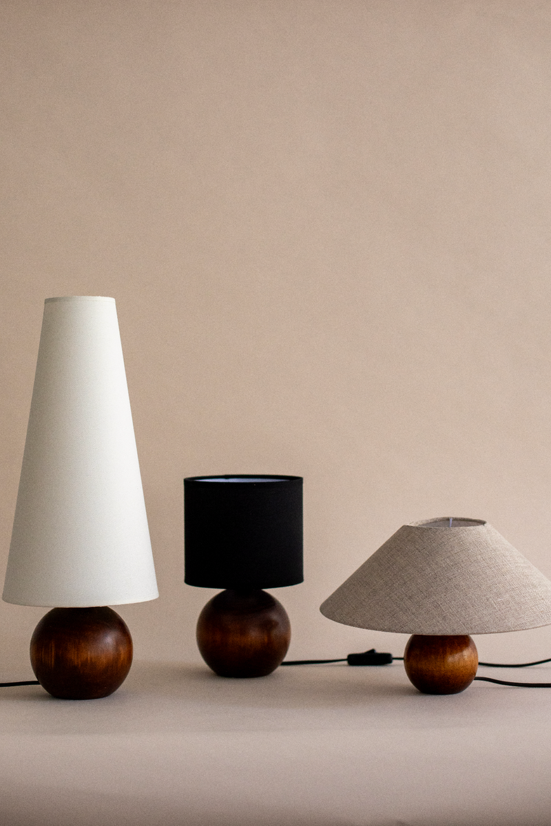 Three wooden table lamps with different shade styles on beige