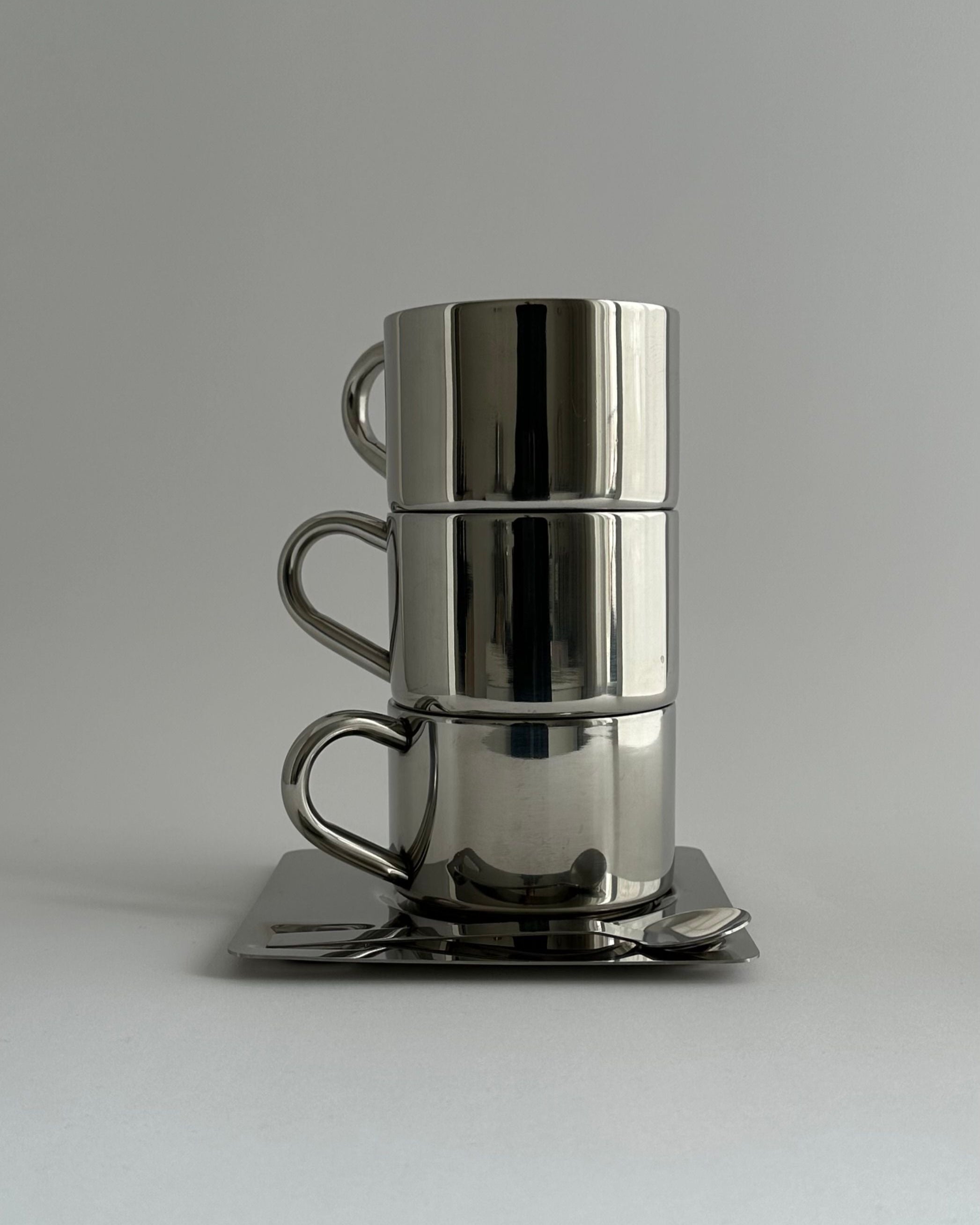 'HEDONISM' stainless steel cup with saucer — detail view