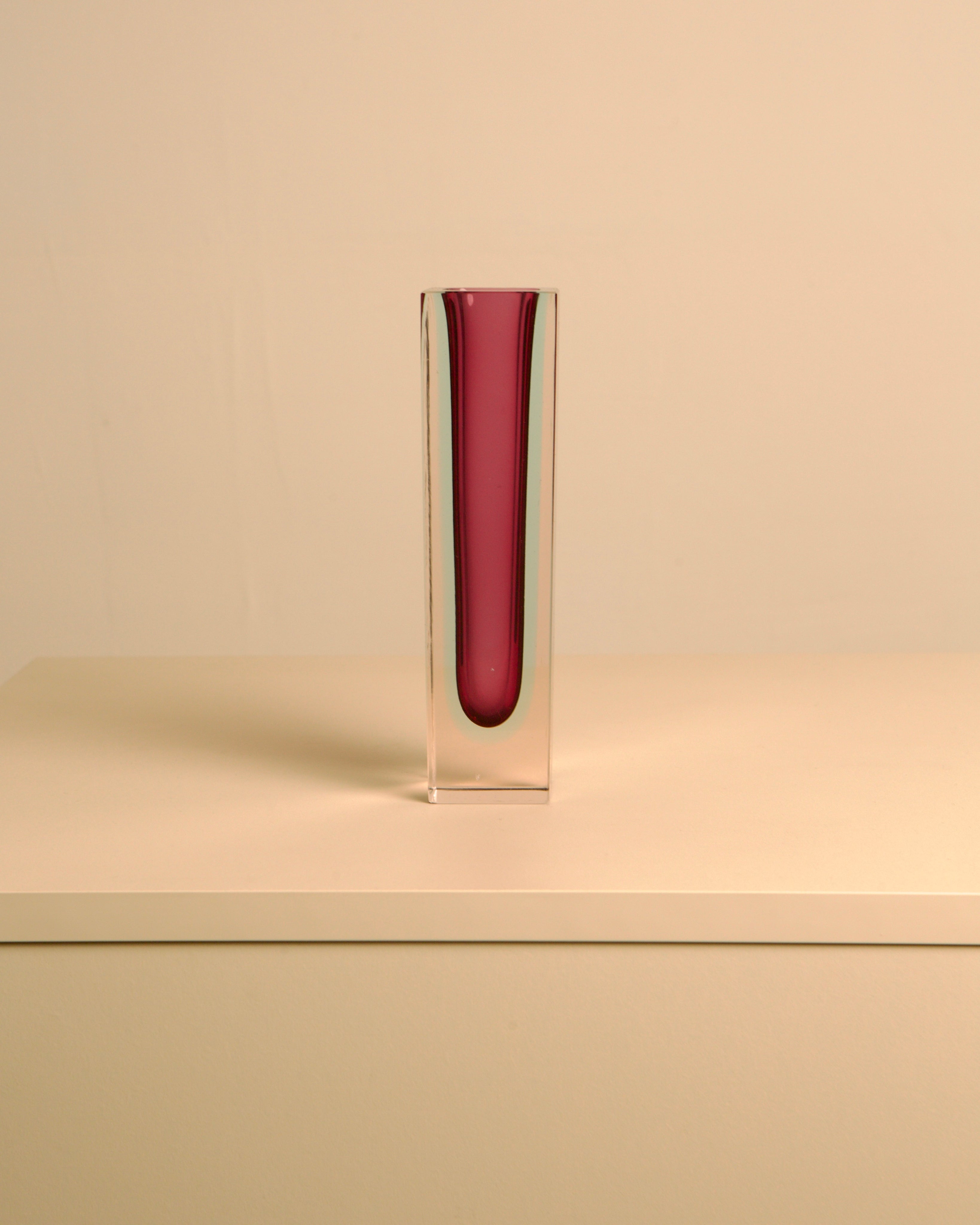 Tall red Murano glass vase in clear block, side view angle