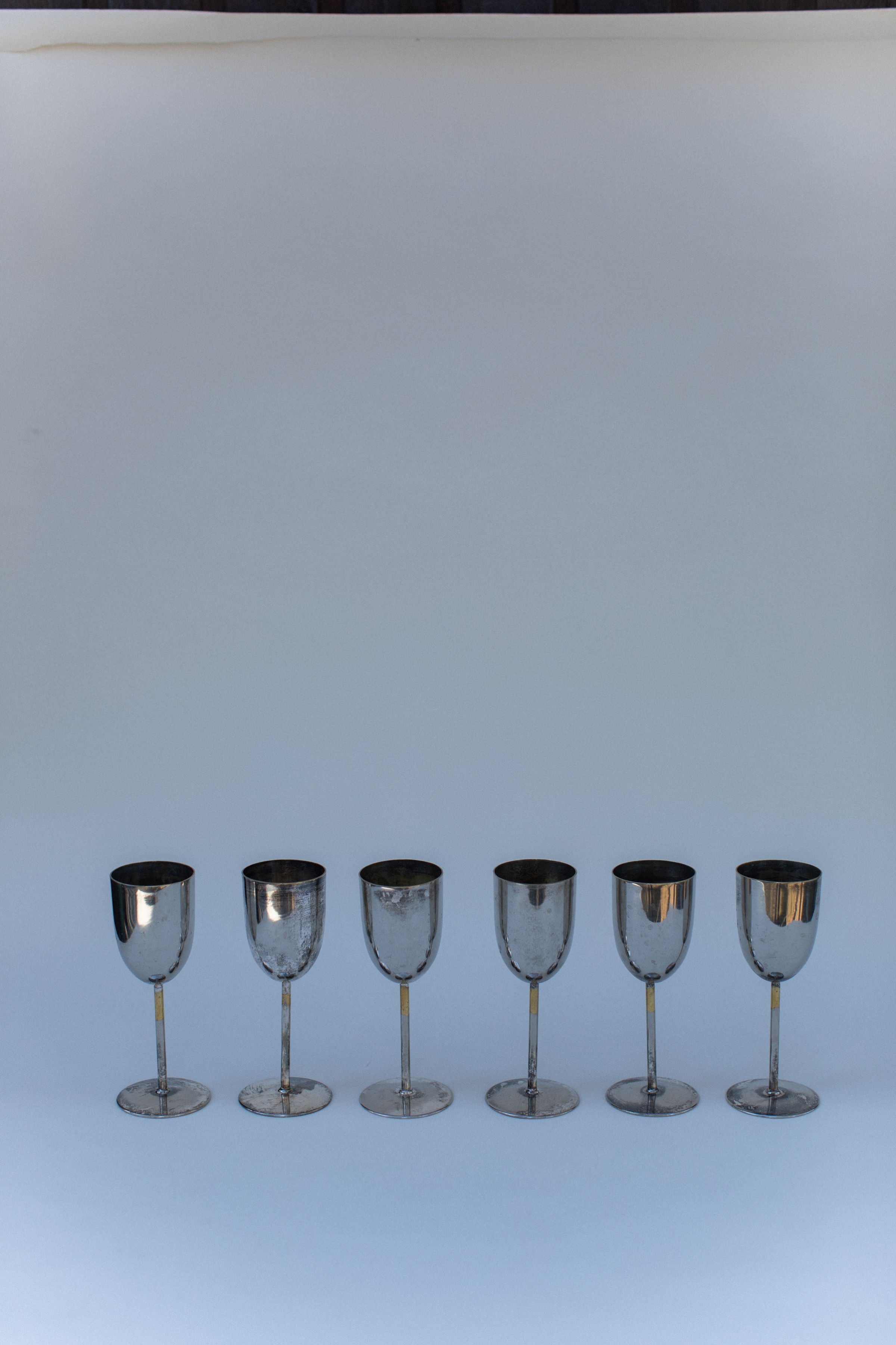 Set of six polished brass champagne flutes arranged in elegant row