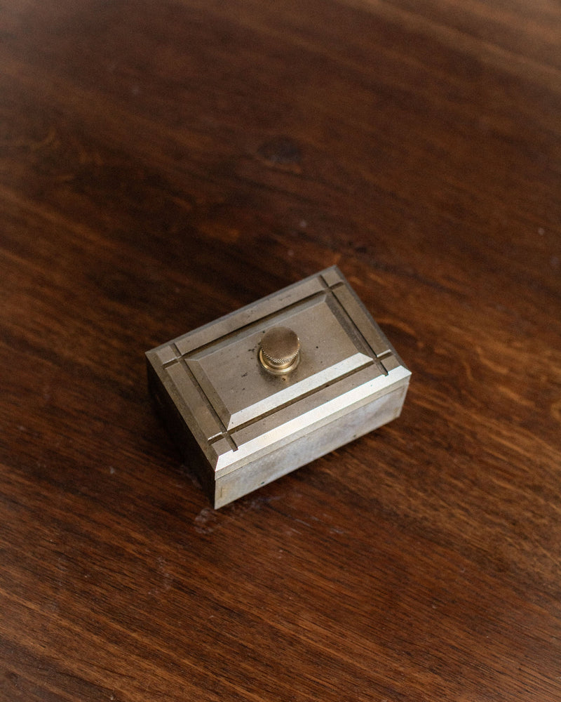 Industrial wooden box with brass knob on rich walnut surface