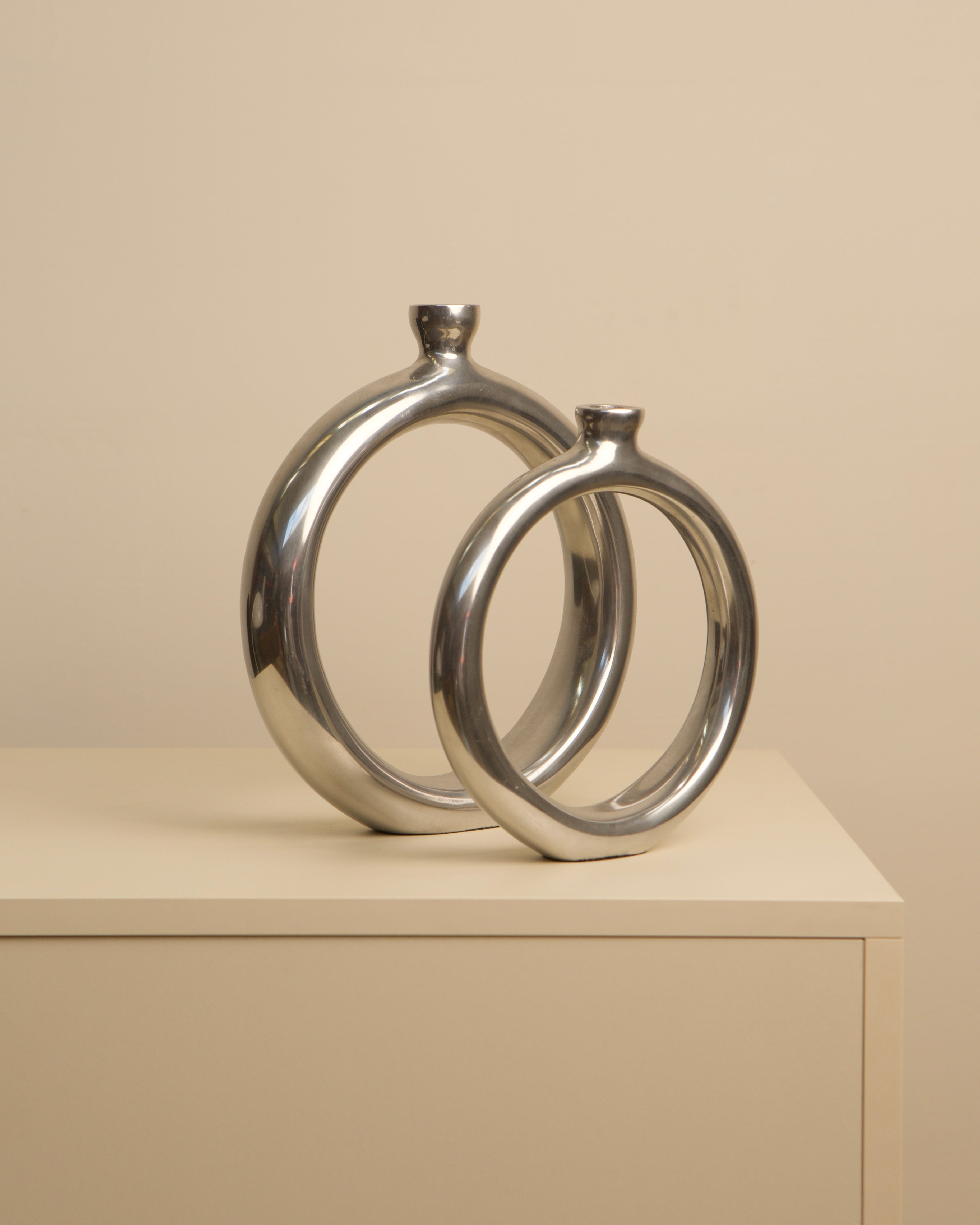 Two circular aluminum vases from 1980s Italy displayed together