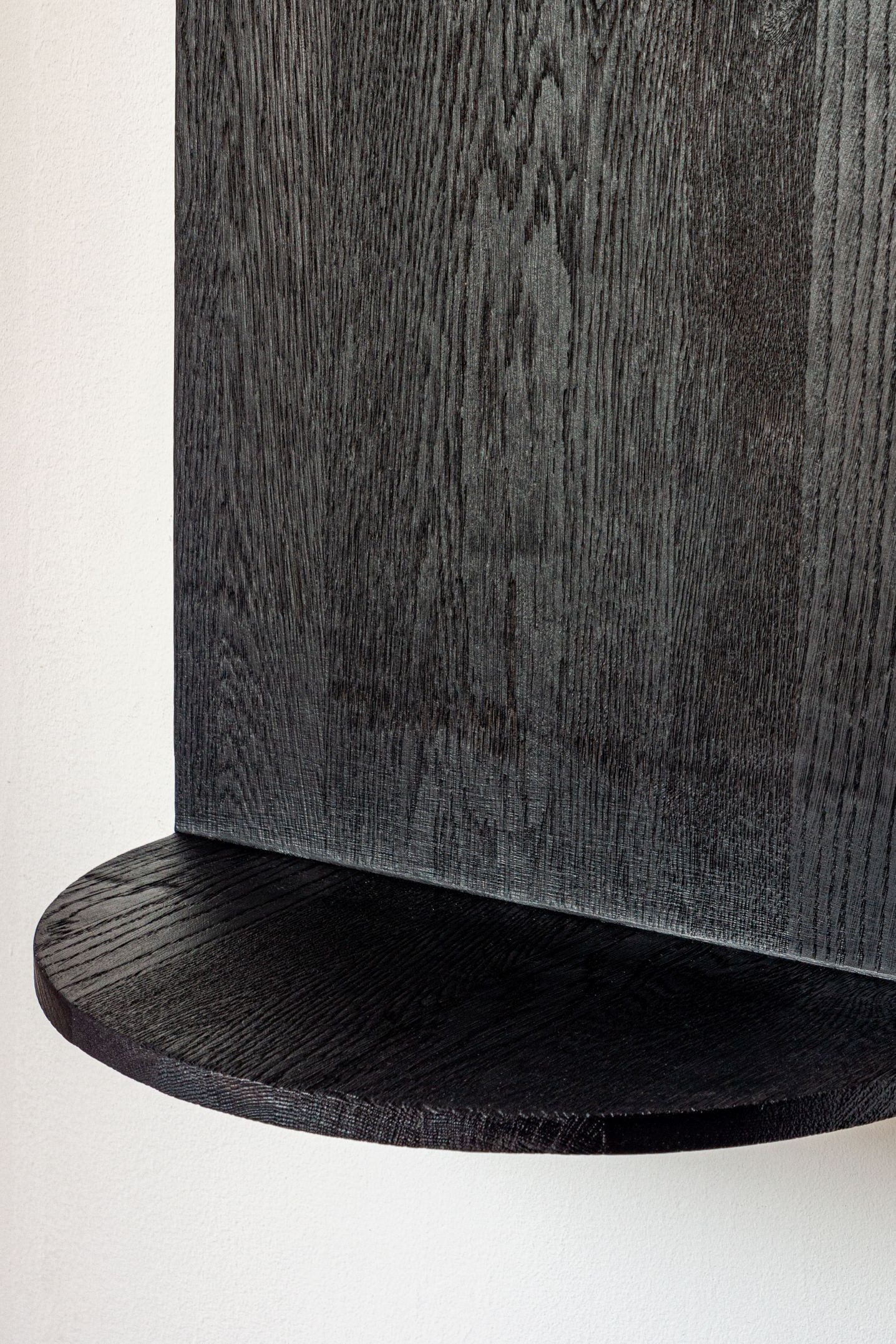 Black oak curved shelf detail showing wood grain texture and rounded edge