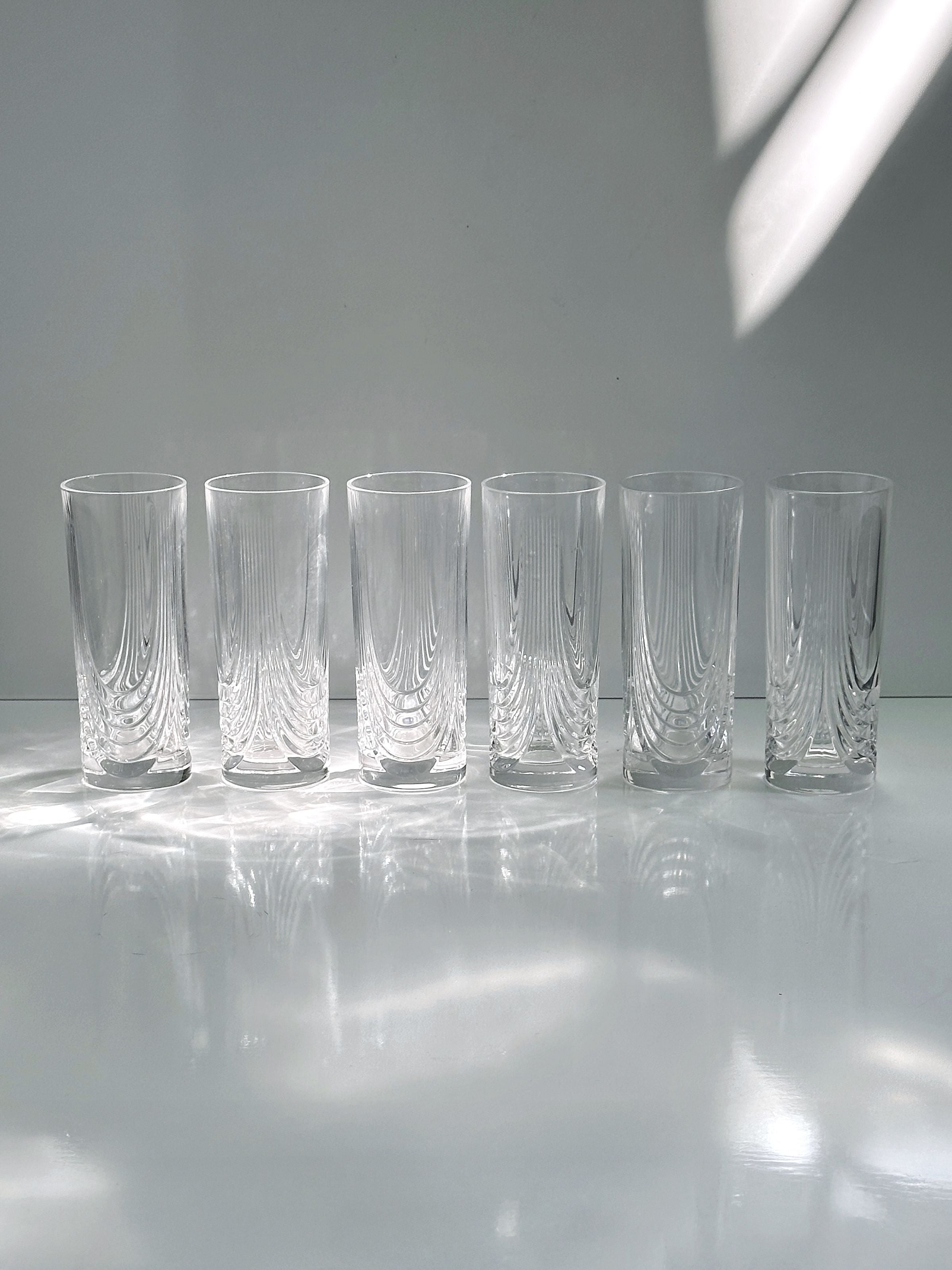 2 Italian Art Deco Crystal Glass Sets of 8 and 6 — back view of clear glass tumblers on white surface