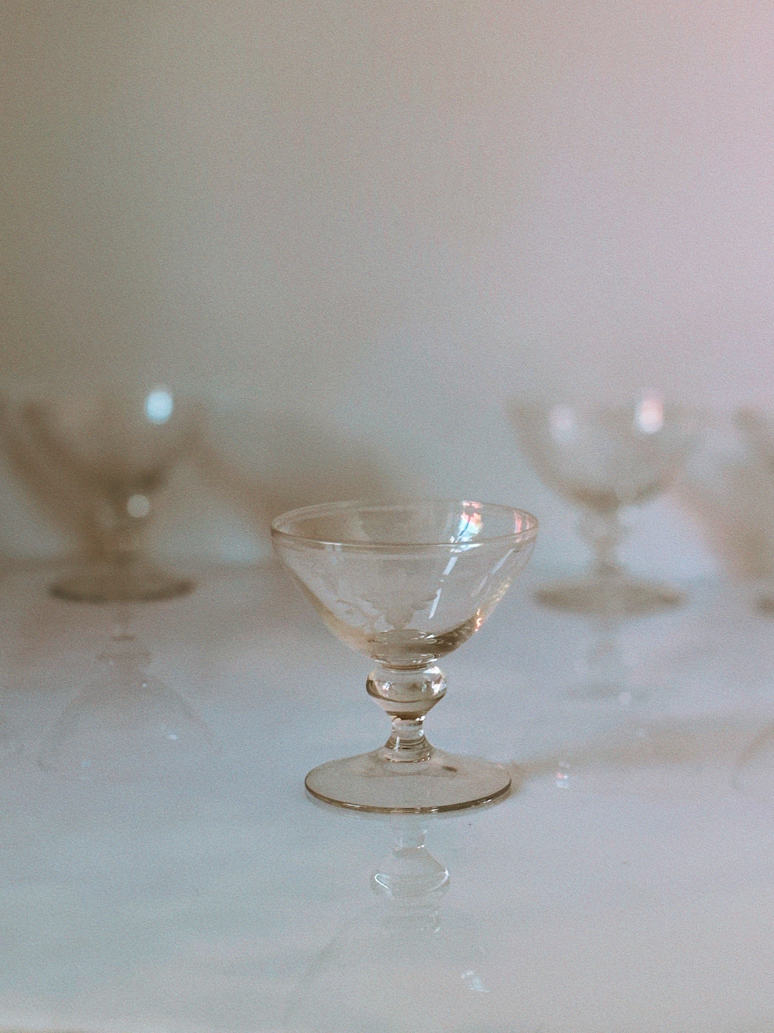 Elegant etched floral dessert wine glass on reflective surface