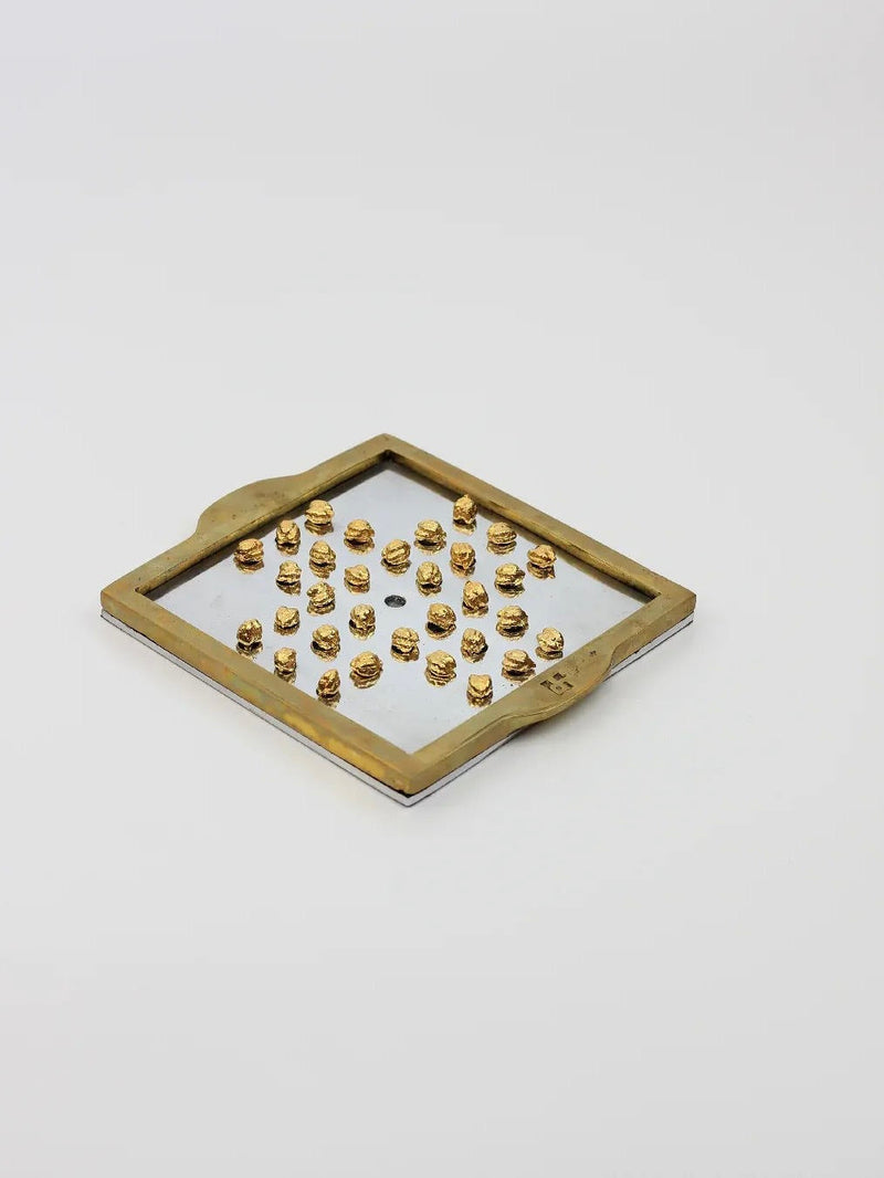 English Solitaire — close-up of brass pegs on mirrored tray