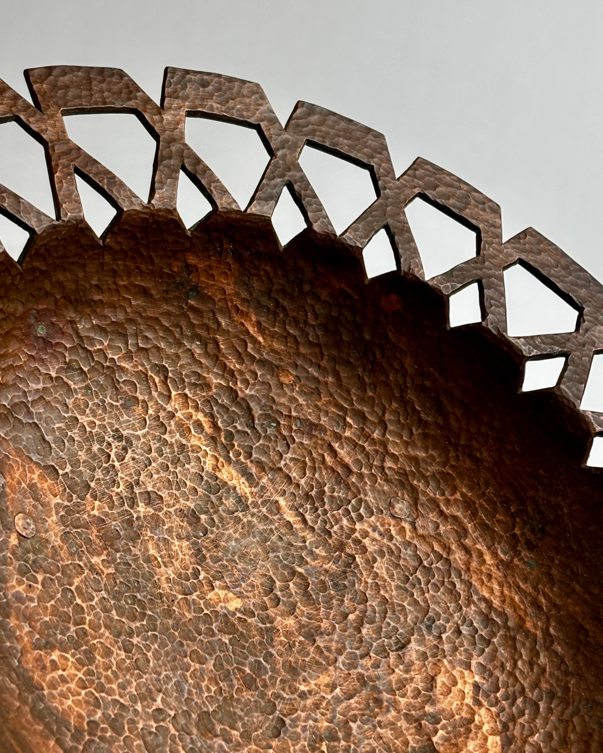 Close-up detail of hammered copper texture and decorative rim edge